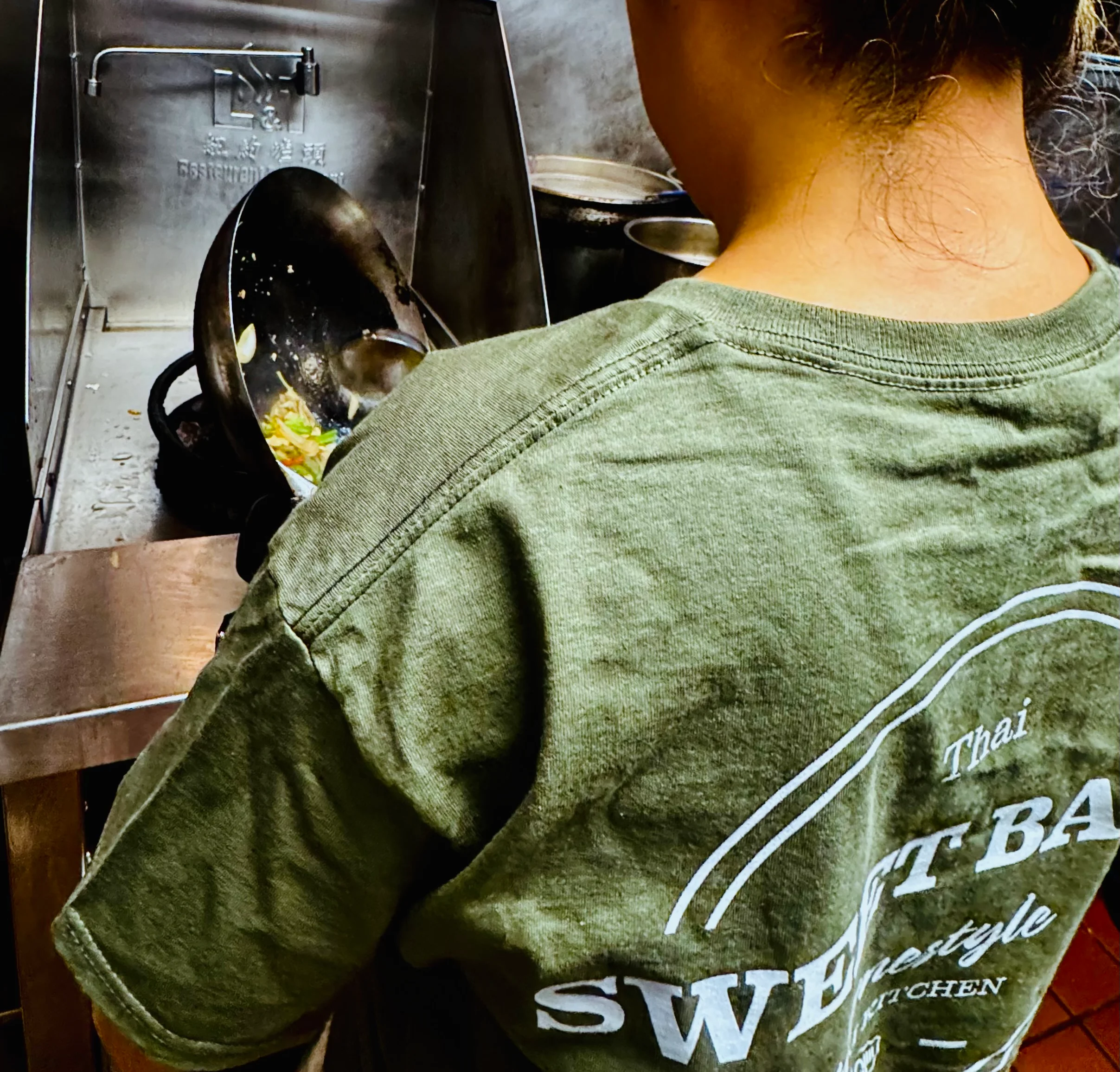 Restaurant worker cooking at a commercial kitchen stove