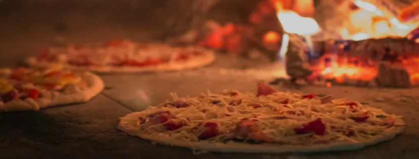 Wood-fired Margherita pizza baking in a traditional oven