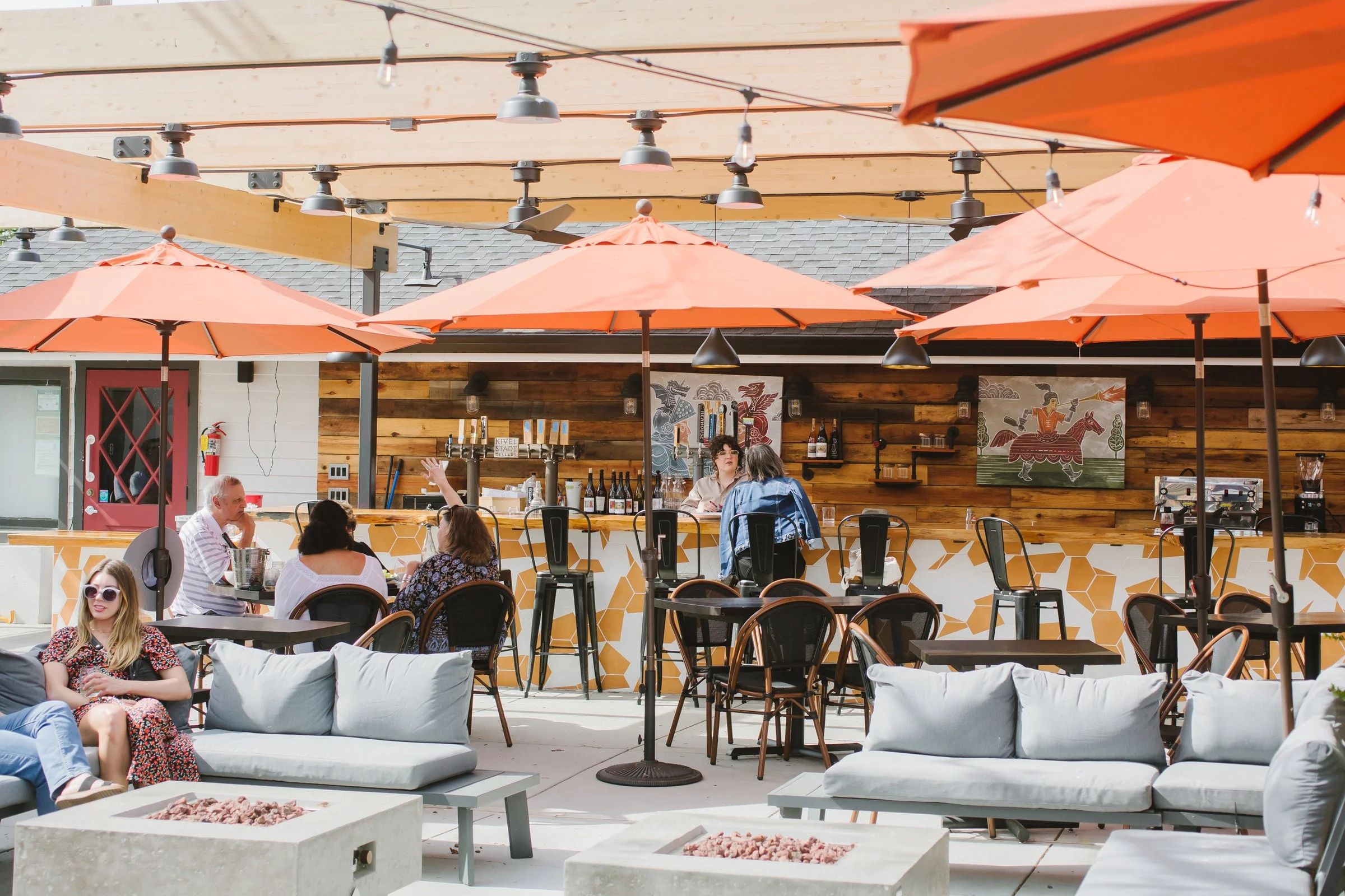 Outdoor dining area with orange umbrellas and modern seating