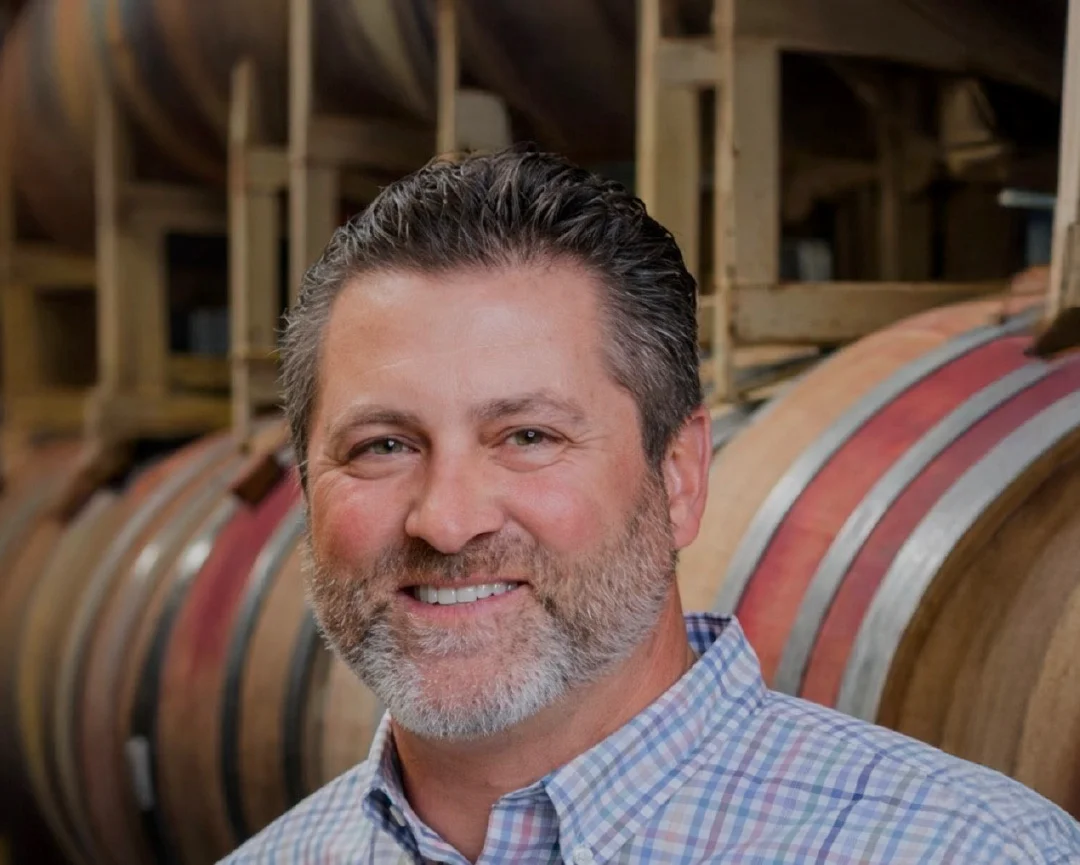 Winemaker holding a glass of red wine in a winery