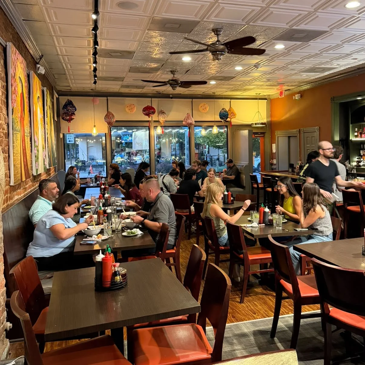 Cozy restaurant interior with warm lighting and vibrant artwork on the walls