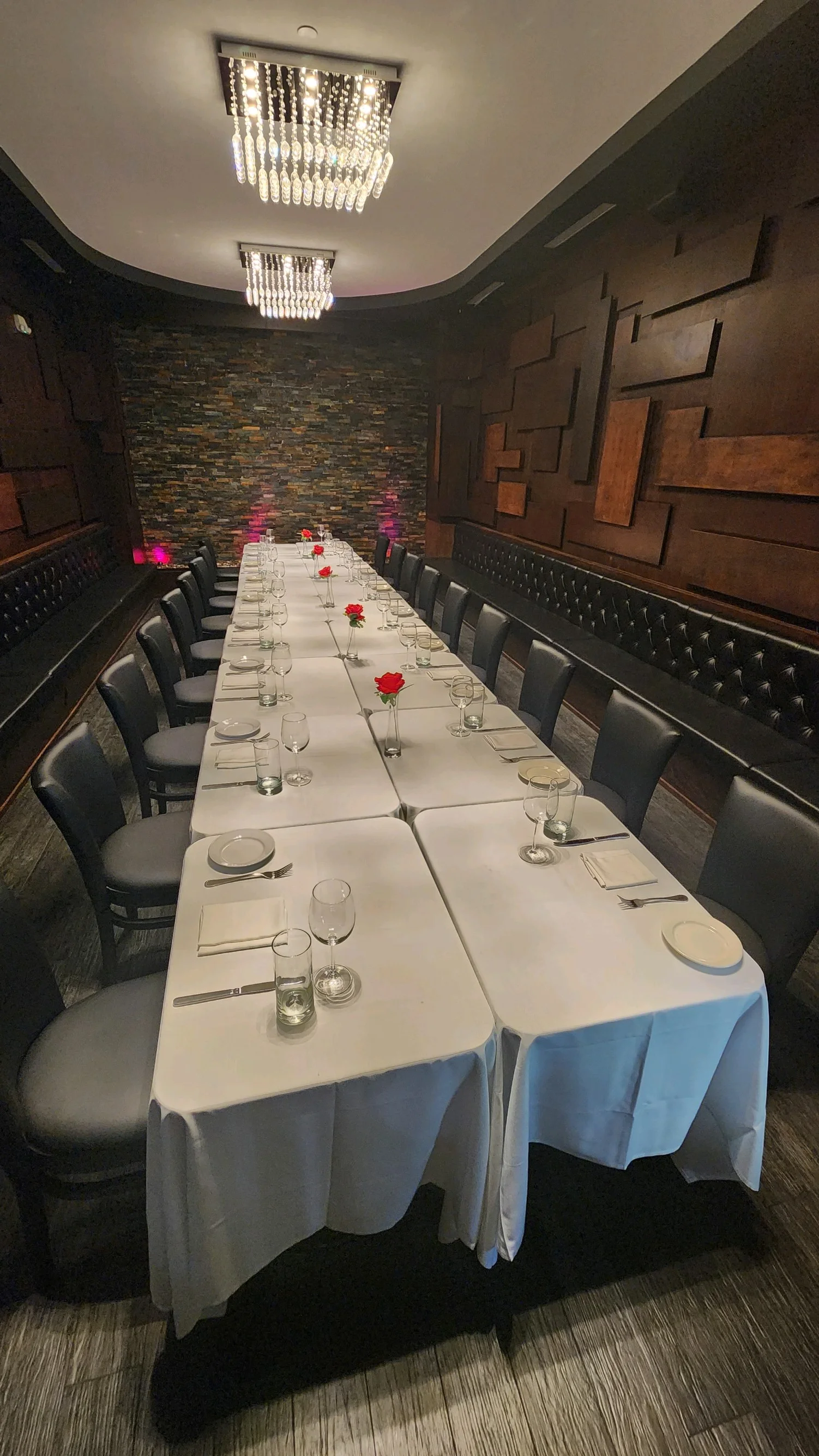 Large dining room with a long white table and several black chairs