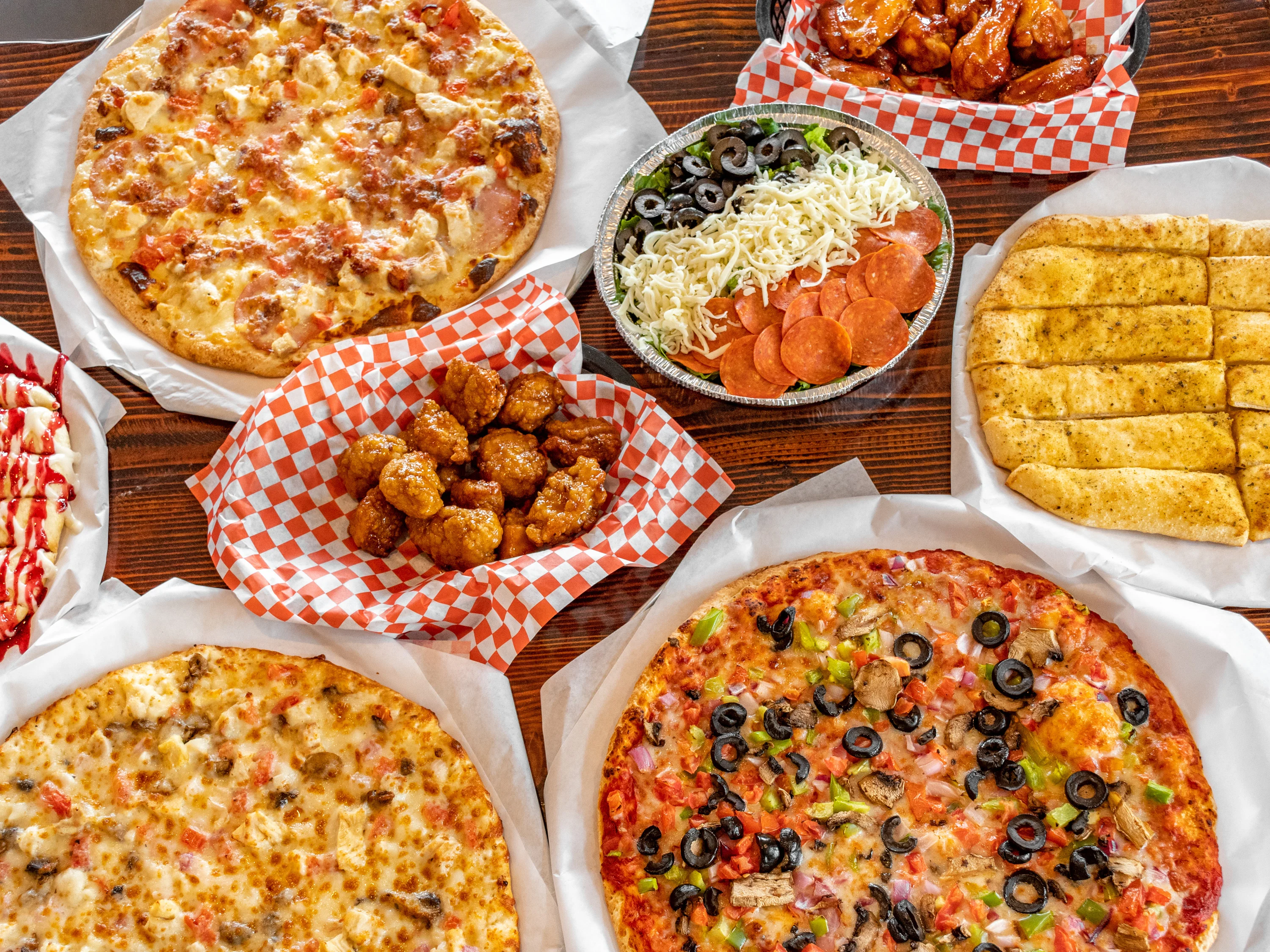 Experience culinary bliss with a stunning spread of gourmet pizzas from Village Pizza, Eagle Mountain's cherished family-owned pizzeria, featuring tantalizing flavors and fresh, quality ingredients.