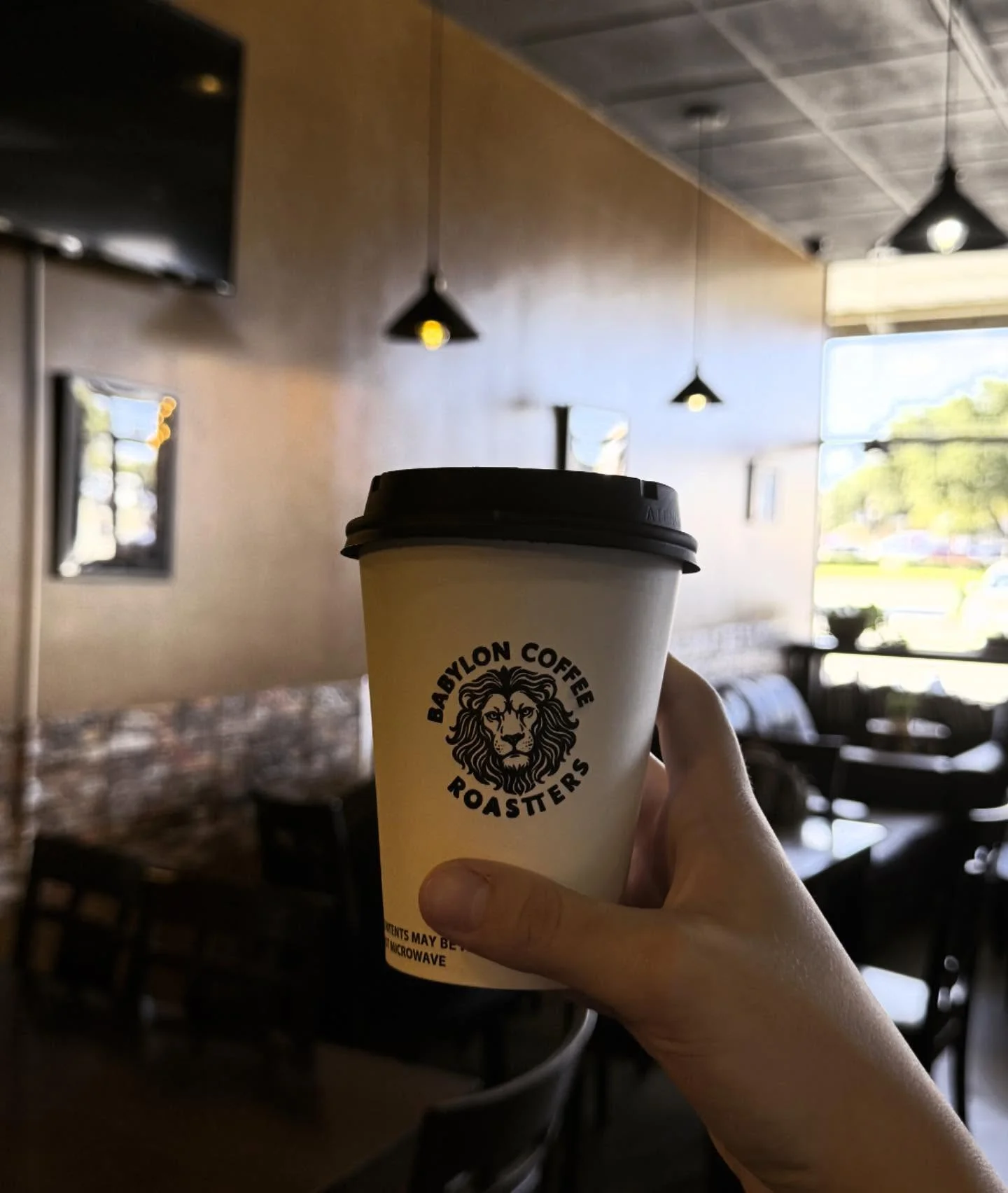 Coffee cup from Babylon Coffee Roasters in a cozy café setting