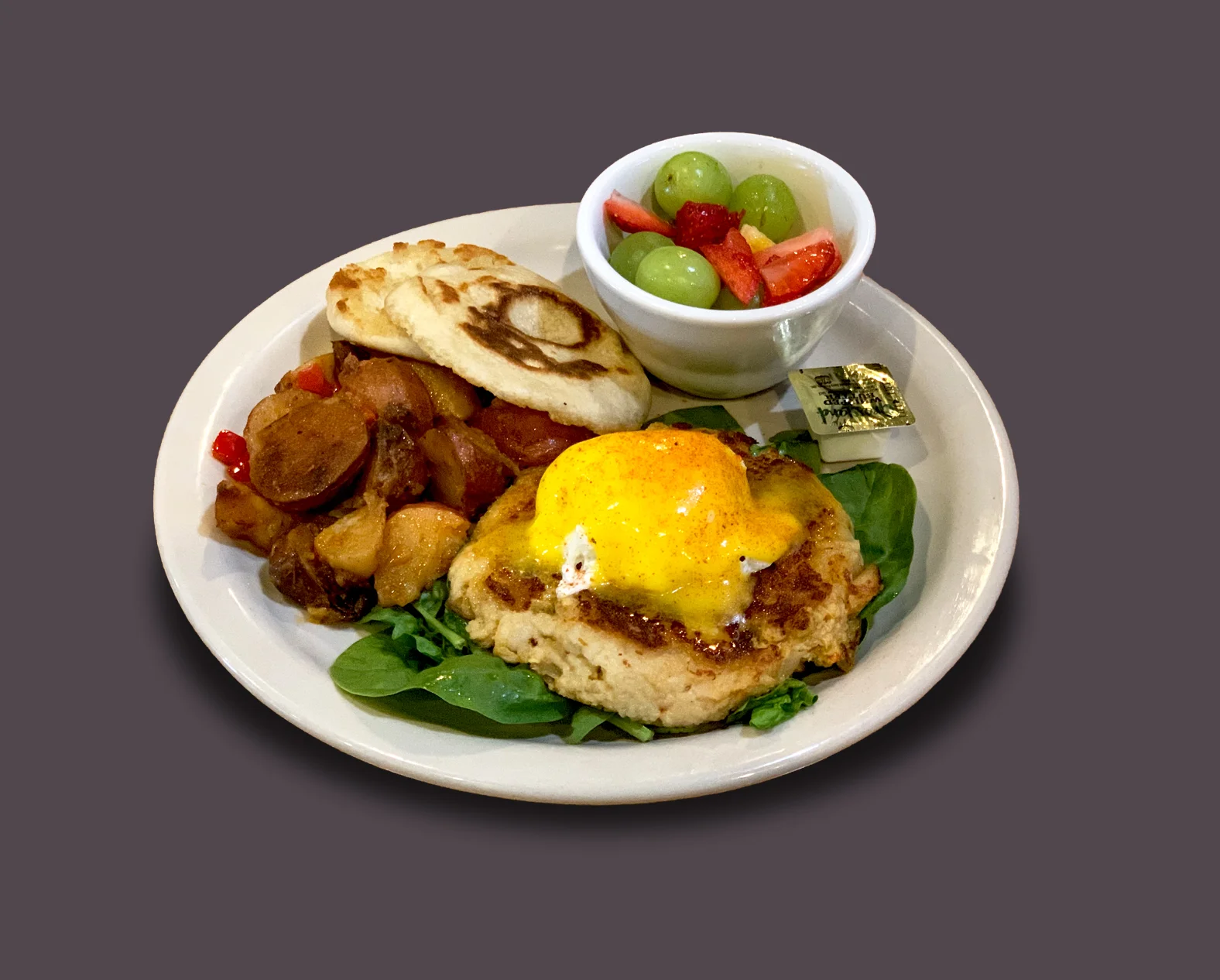 Crab cake eggs benedict with fresh fruit and roasted potatoes