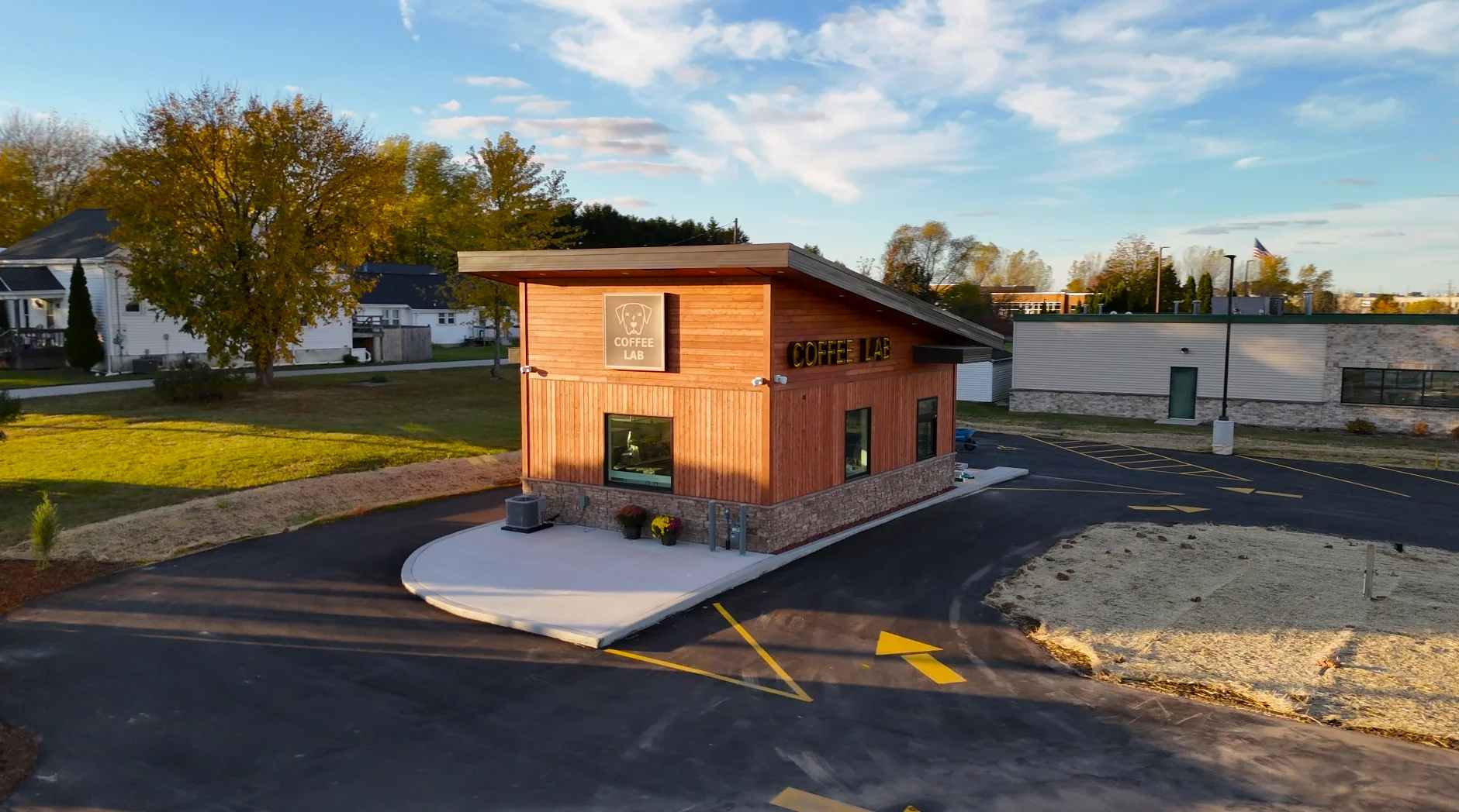 Exterior view of a modern coffee shop with wooden facade and signage.