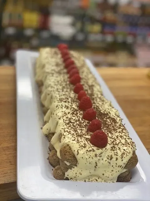 Classic Italian tiramisu with raspberries and cocoa powder
