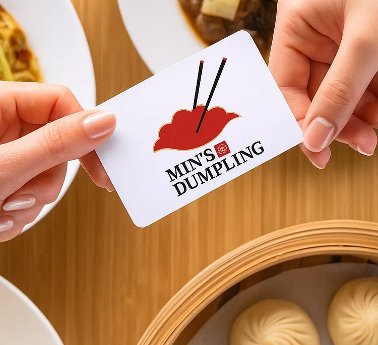 Hands holding a loyalty card for Min's Dumpling restaurant