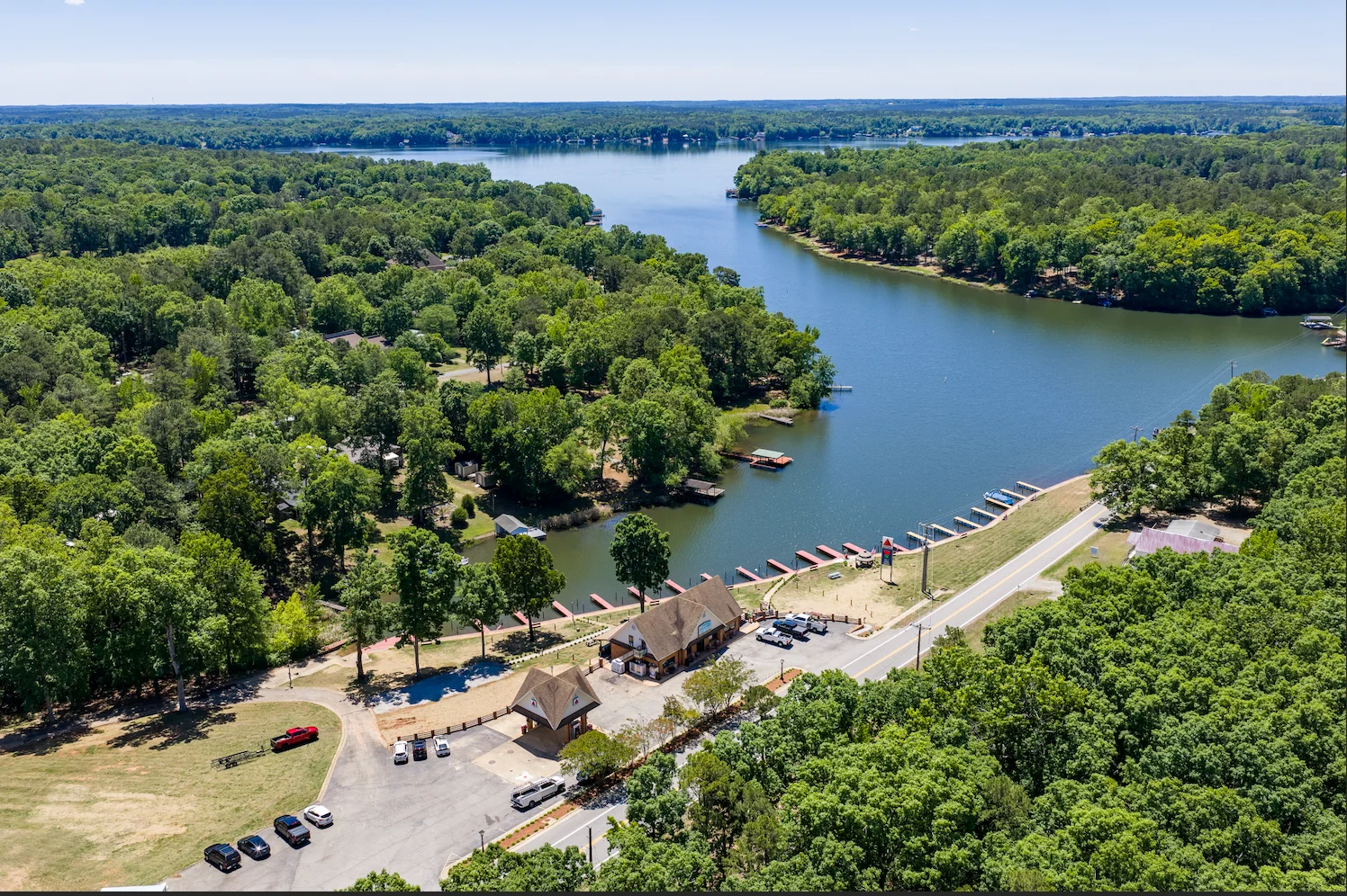 Aerial view of a scenic lake surrounded by greenery and a restaurant area.