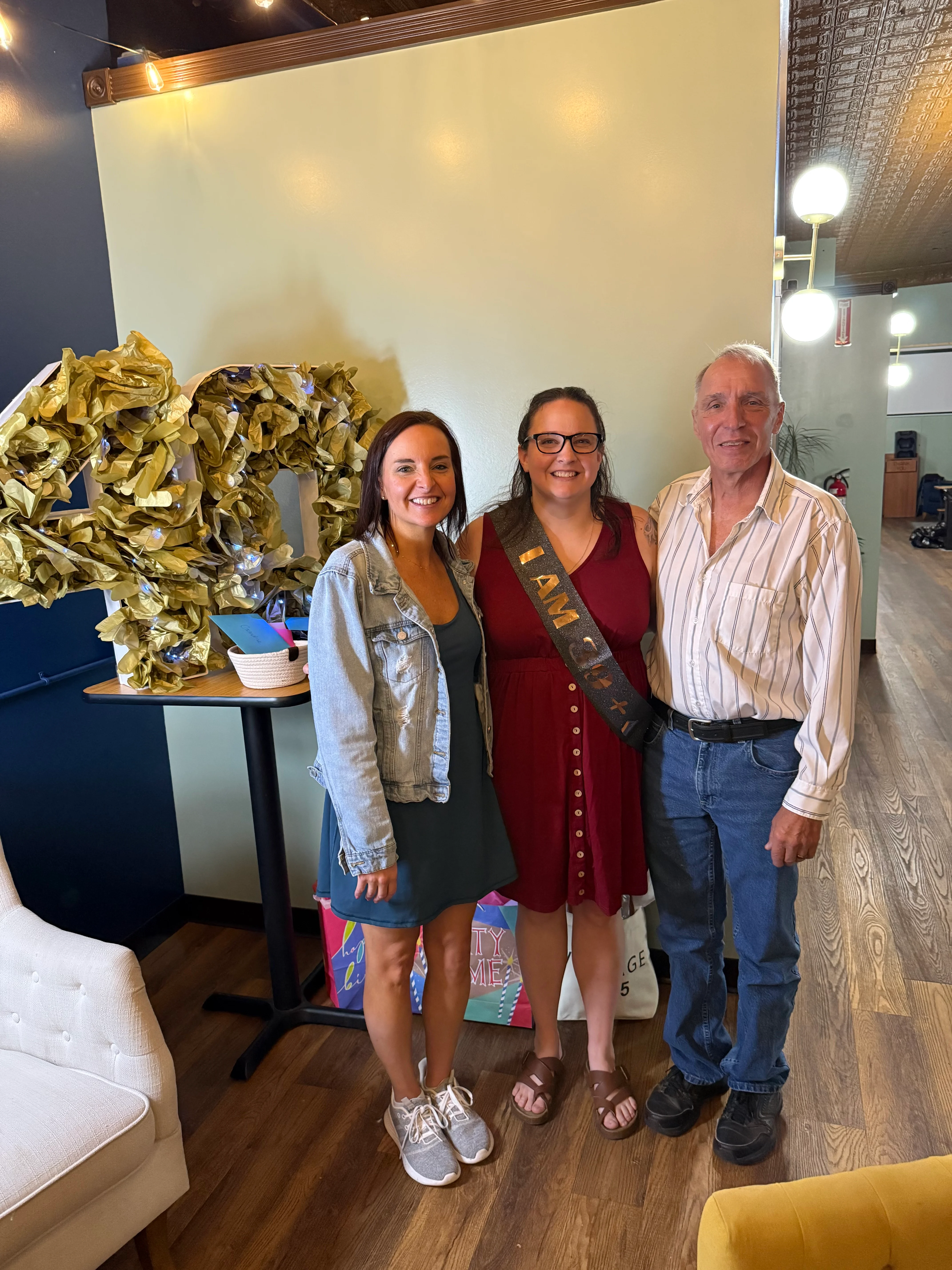 Two women and a man at a 40th birthday party celebration