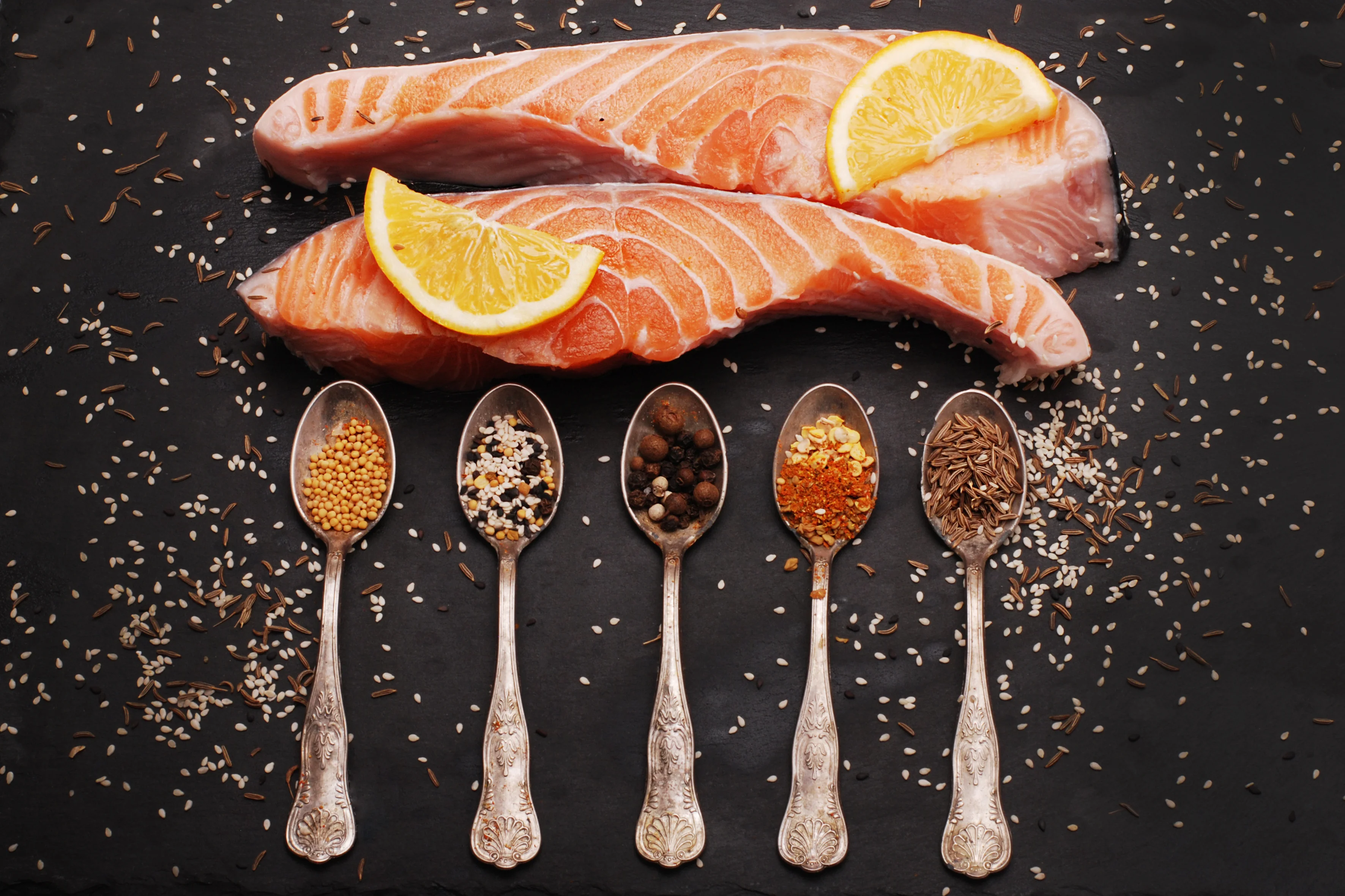 Fresh salmon fillets with spices and lemon, ready for grilling