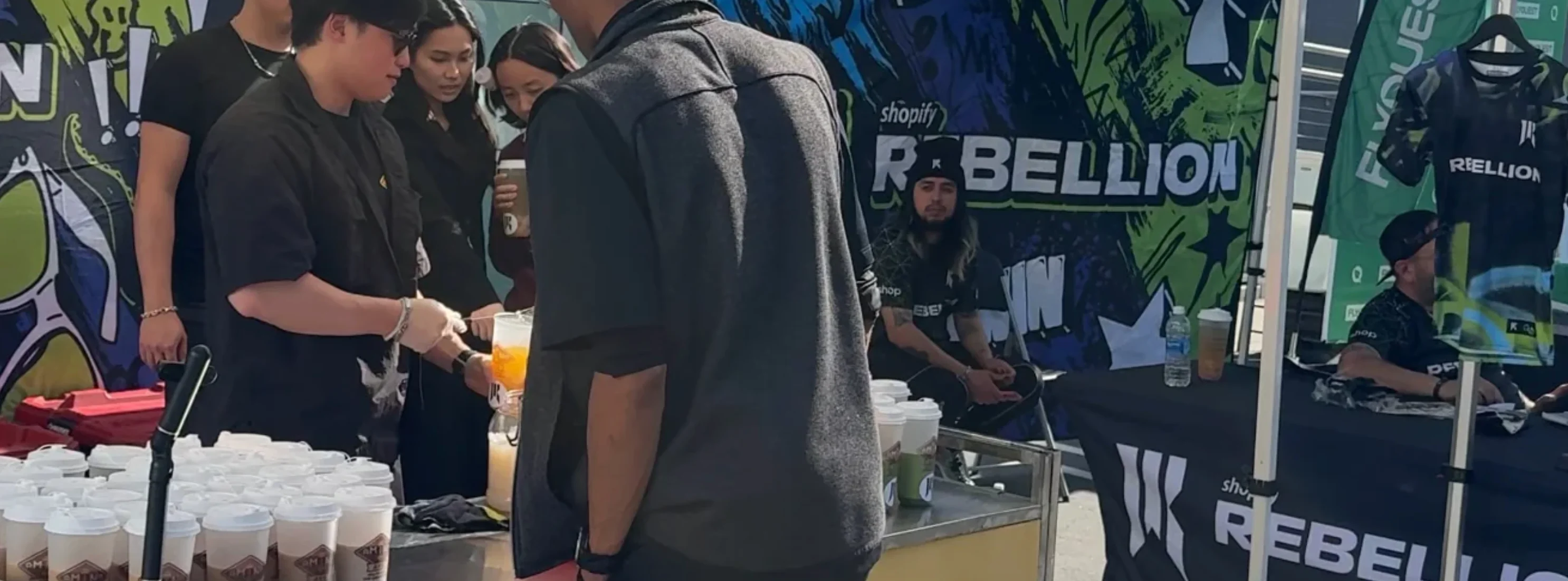 Event staff serving drinks at a vibrant outdoor festival booth