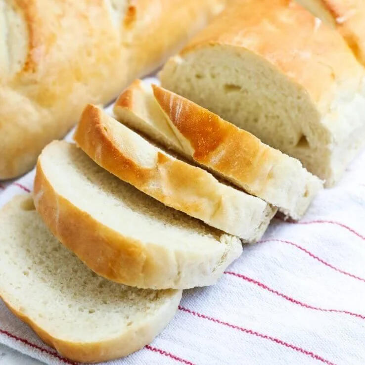 Freshly sliced white bread on a kitchen towel