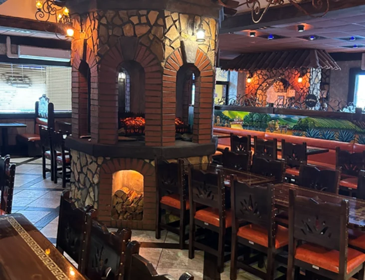 Cozy restaurant interior with stone fireplace and wooden seating