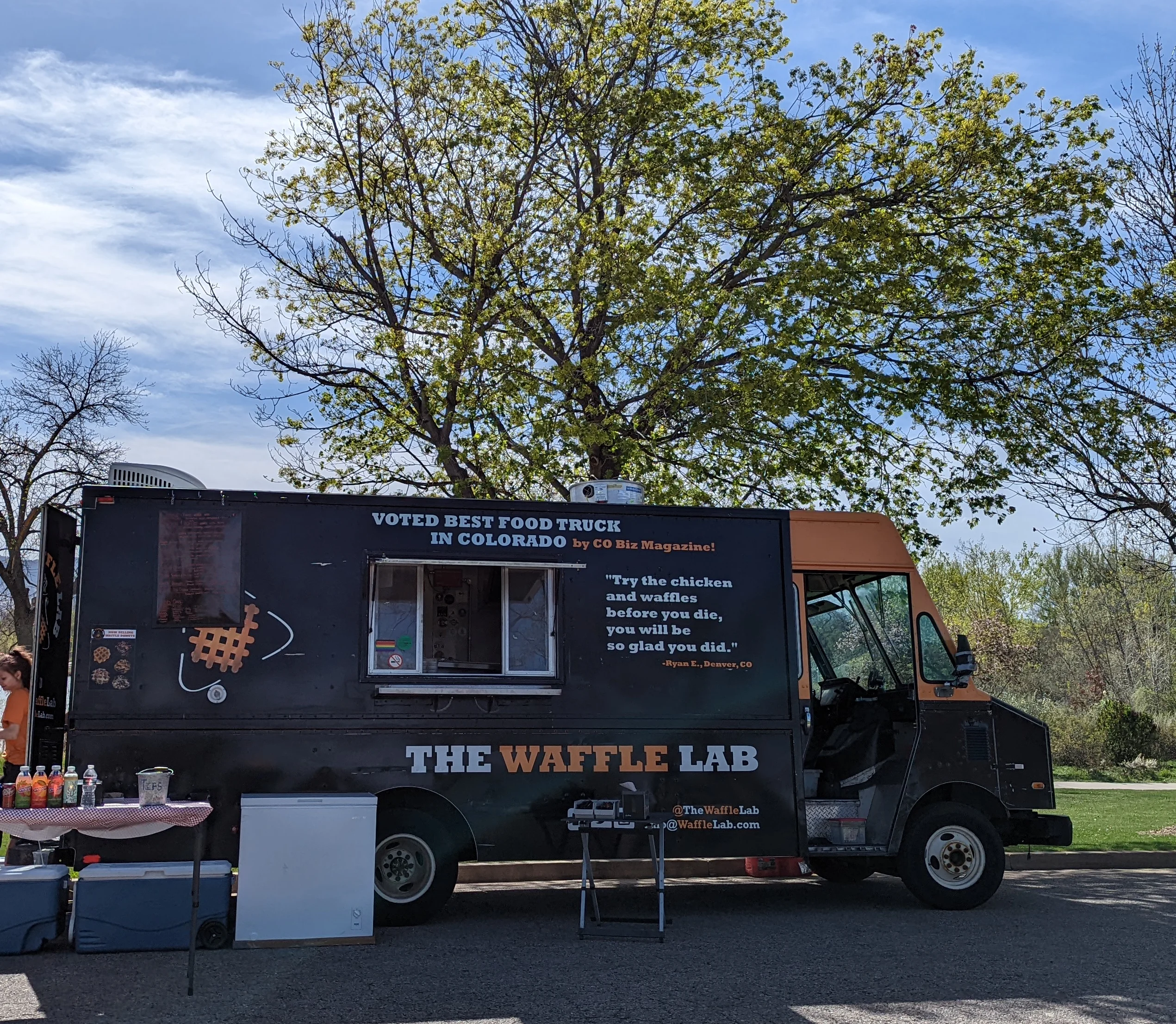 A vibrant food truck setup with colorful signage and outdoor seating.