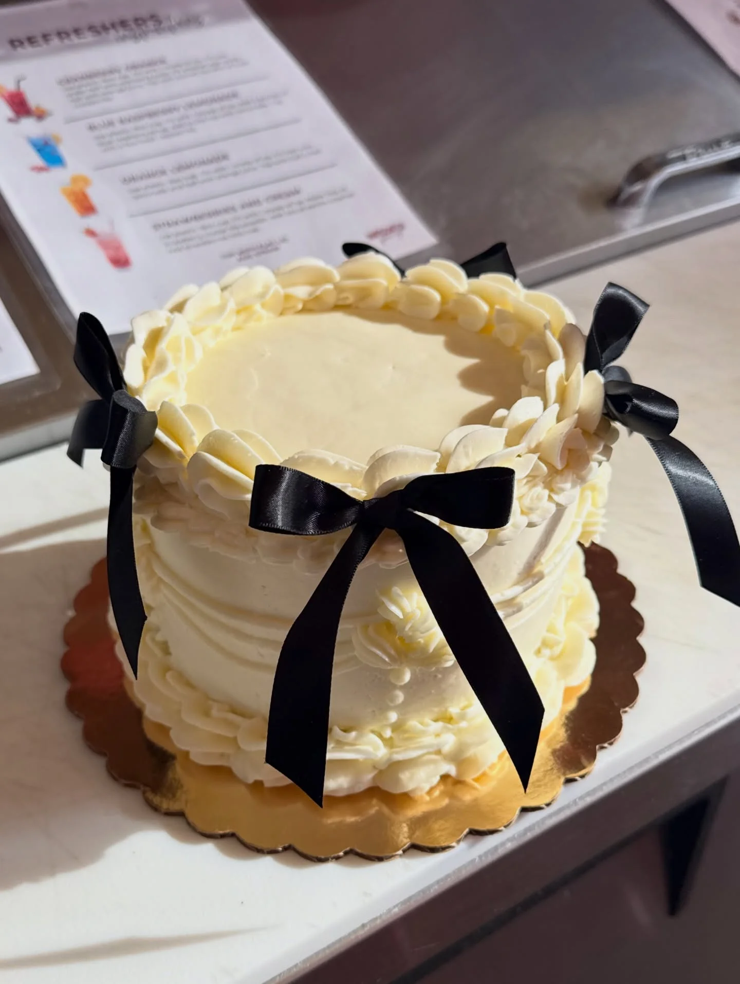 Elegant white cake with black ribbons and decorative frosting