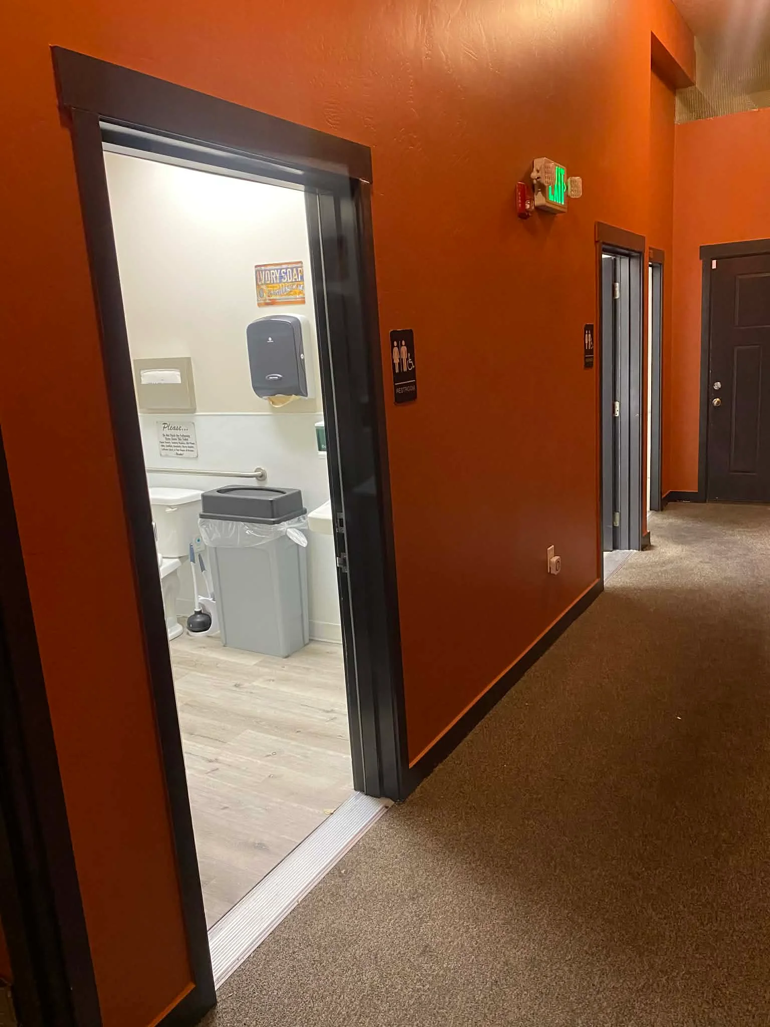 Restroom entrance in a modern restaurant with orange walls