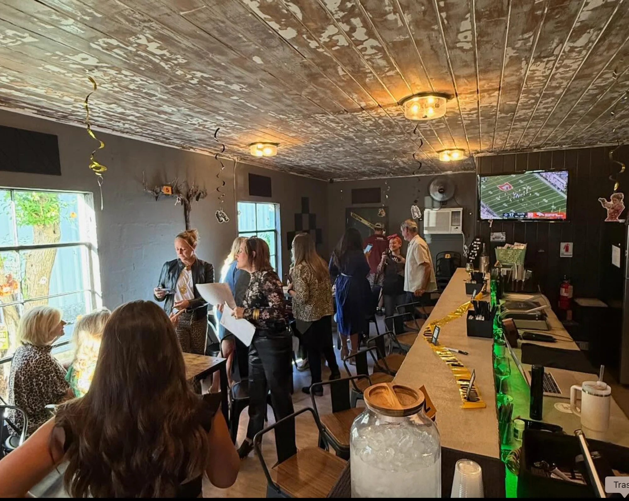 Cozy restaurant interior with guests enjoying drinks and conversation