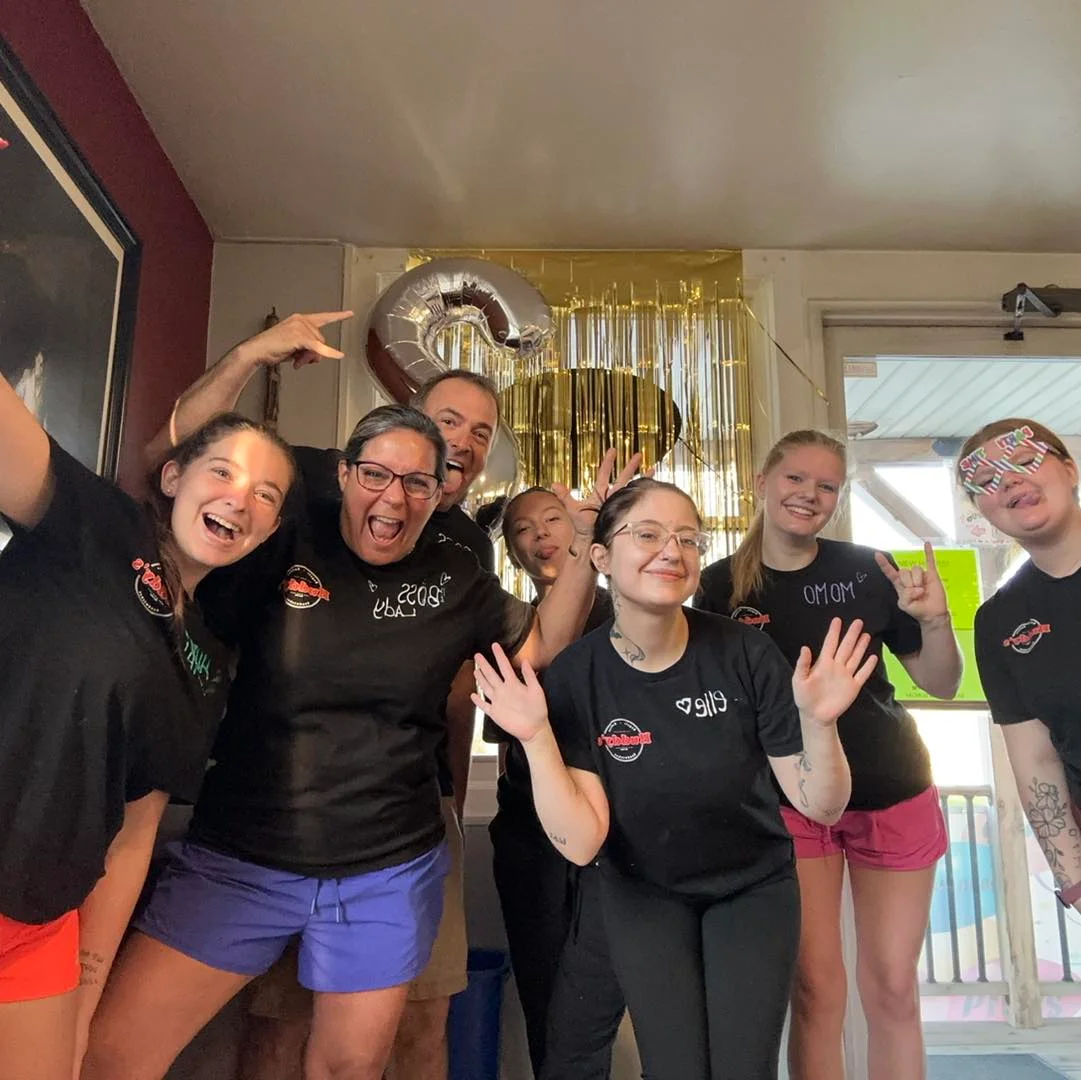 A diverse restaurant crew smiling together in a welcoming environment.
