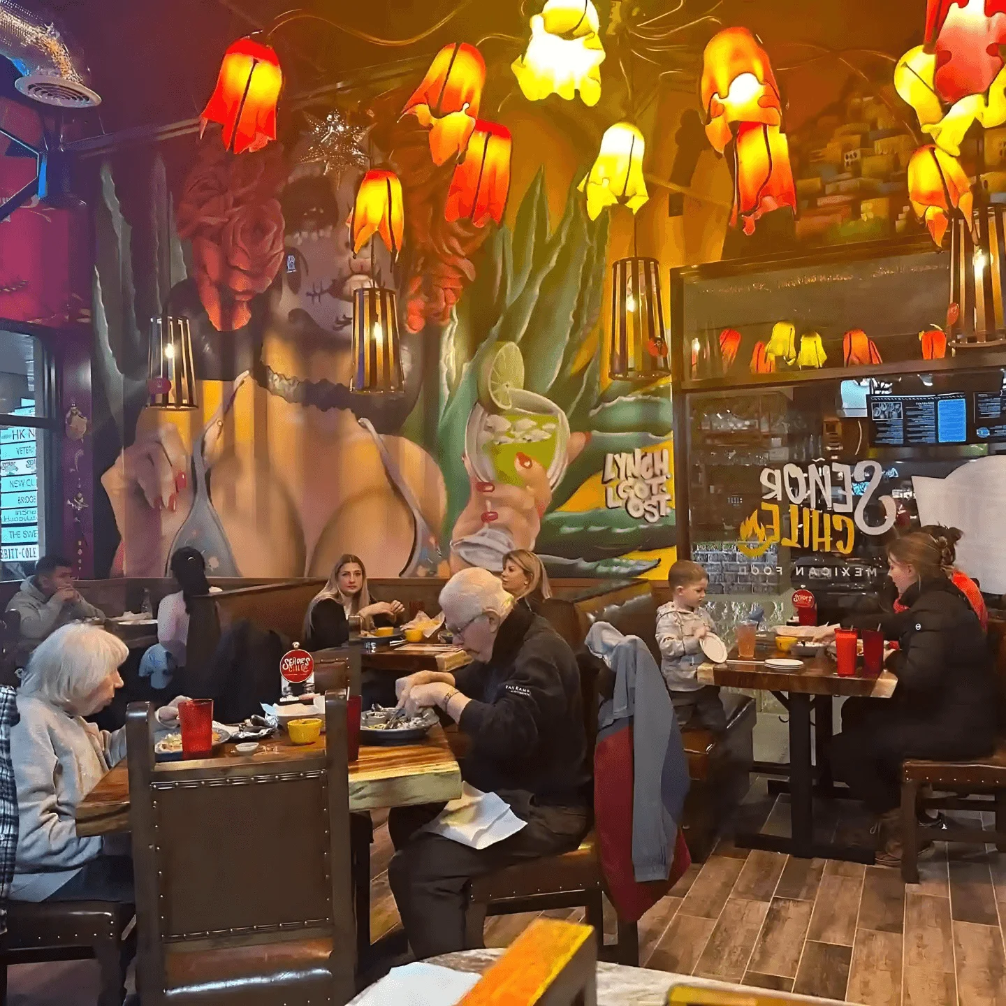 Vibrant restaurant interior with colorful lighting and mural art