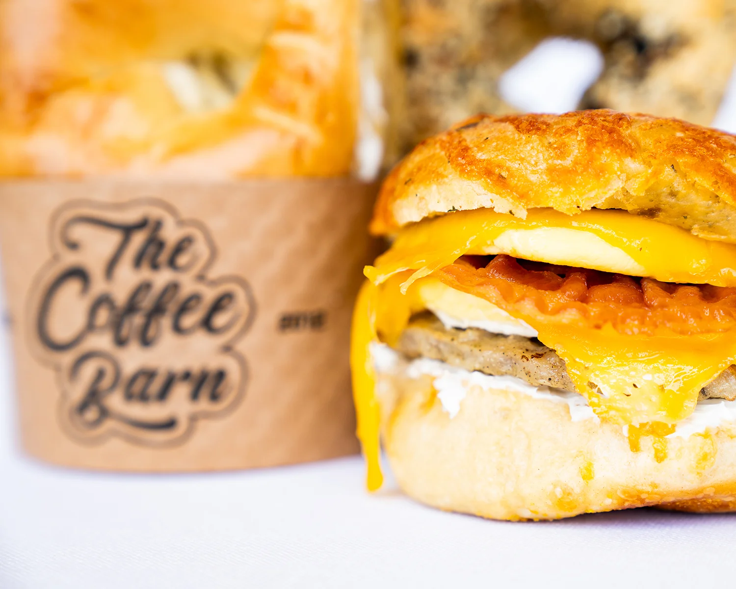 the coffee barn bagel sandwich sausage bacon egg dripping cheese