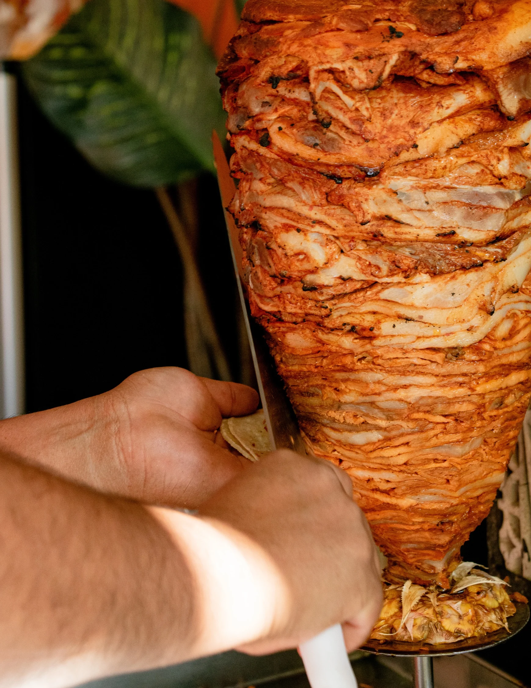 Slicing shawarma from a vertical rotisserie