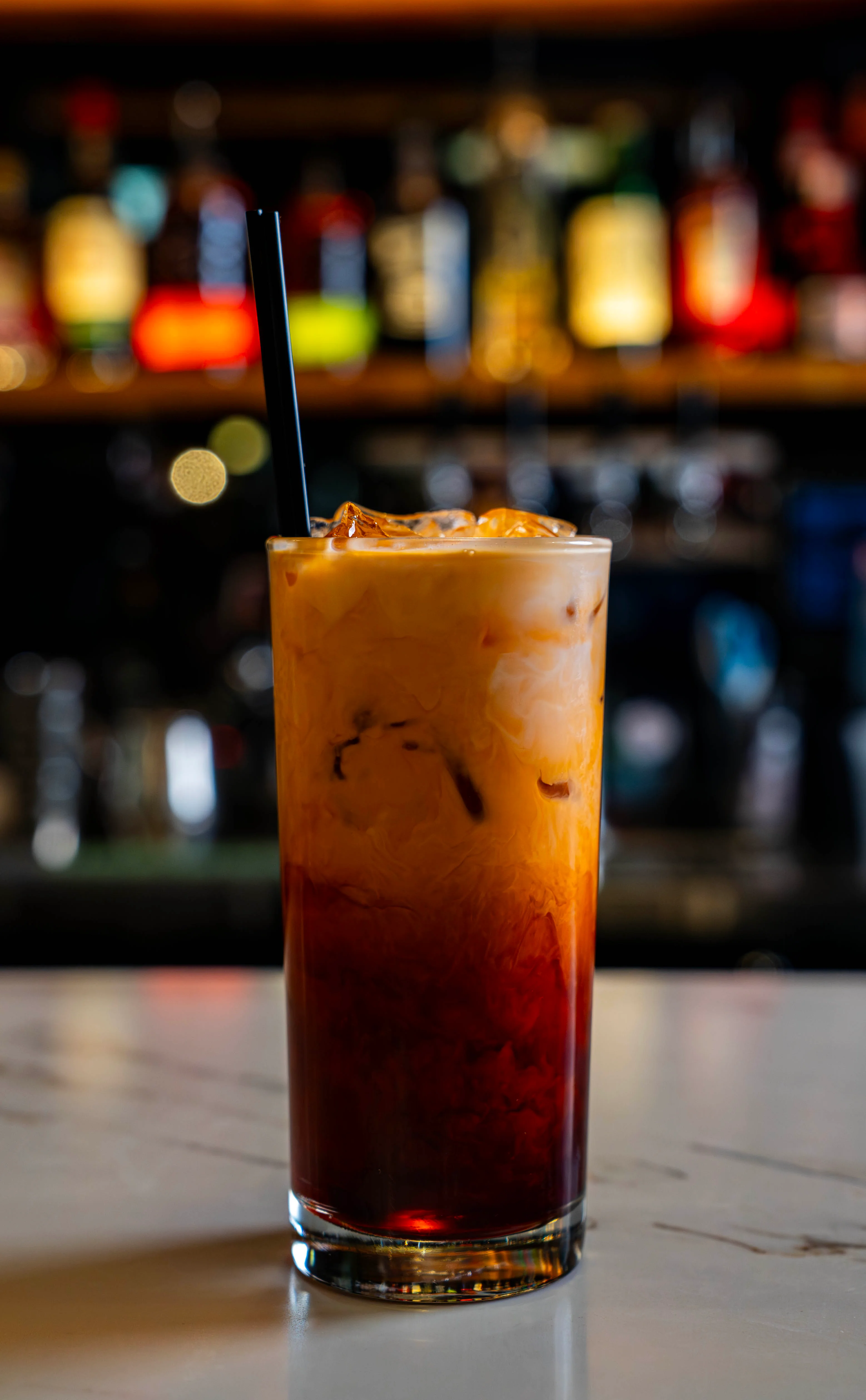 A refreshing glass of Thai iced tea with a creamy top.