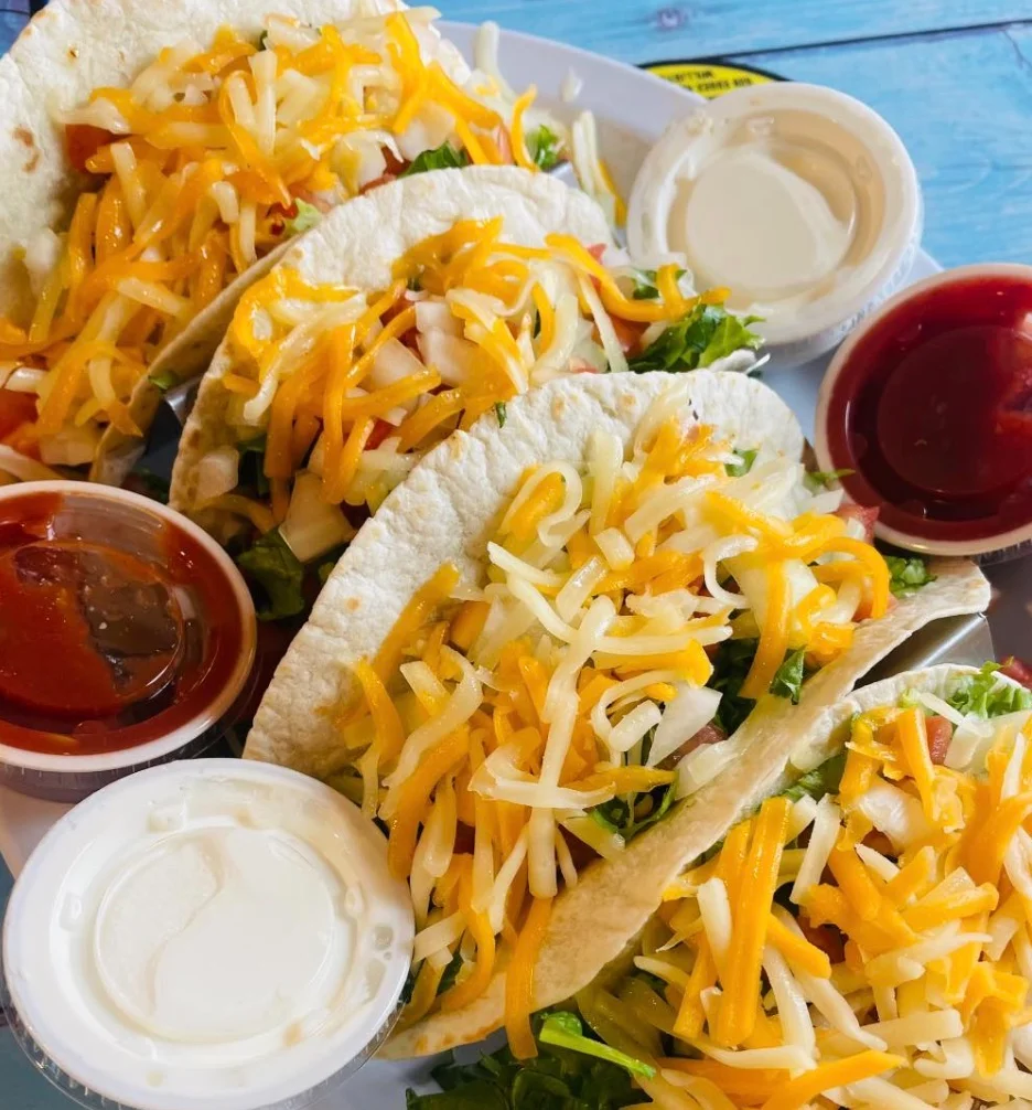 Delicious plate of classic American tacos with cheese and toppings