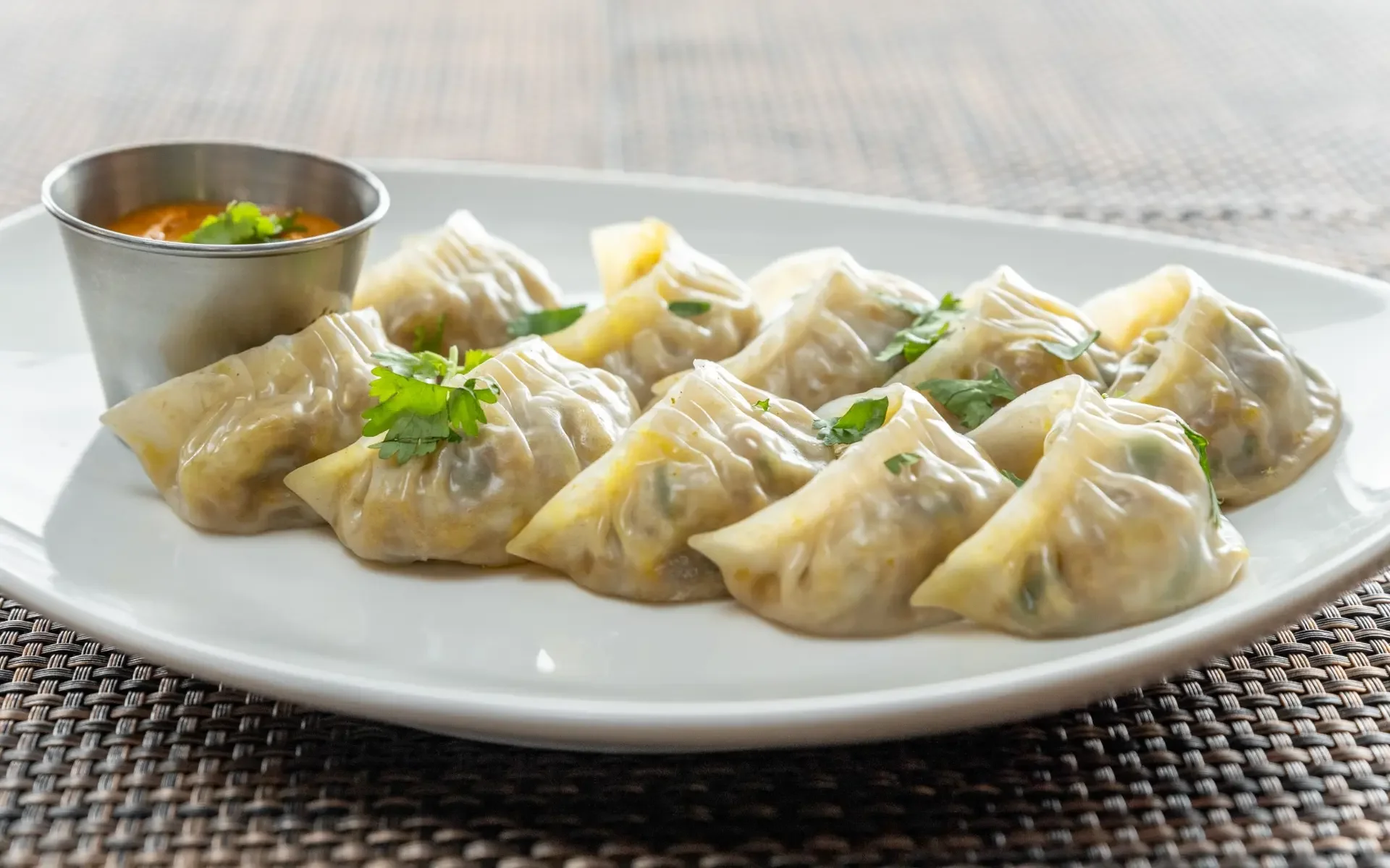 Plate of Nepali momos served with dipping sauce