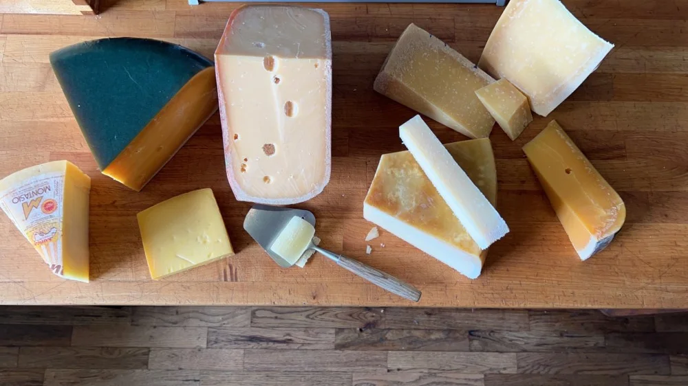Assorted gourmet cheeses on a wooden board