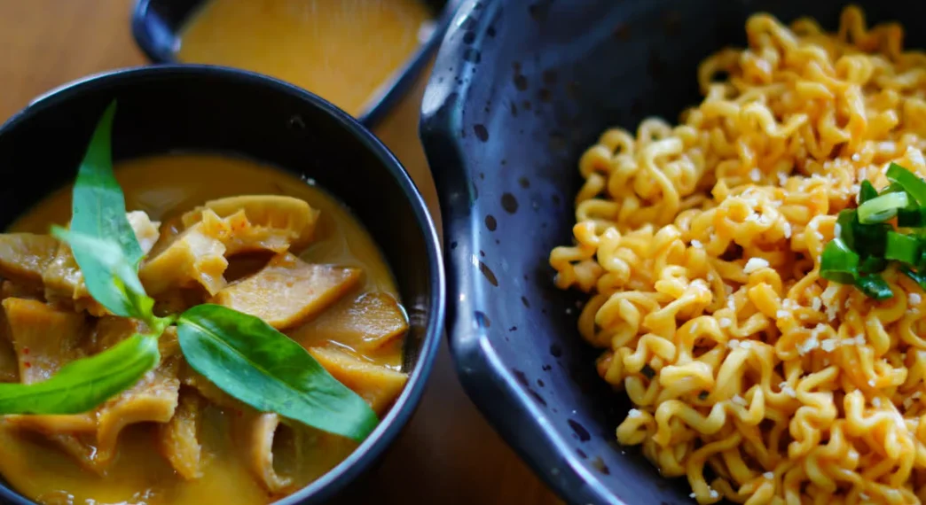 Bowl of Thai curry with noodles and fresh herbs