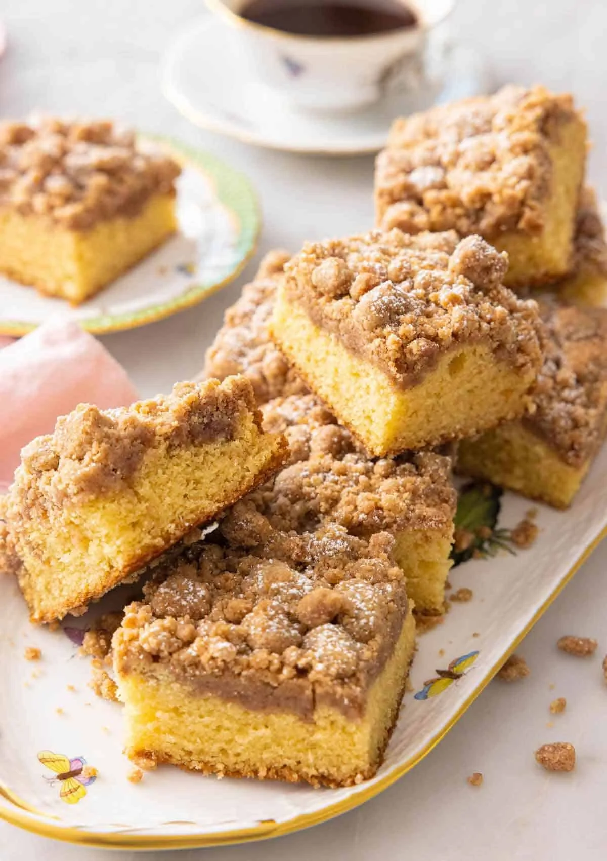 Delicious coffee cake squares with crumb topping on a decorative platter.