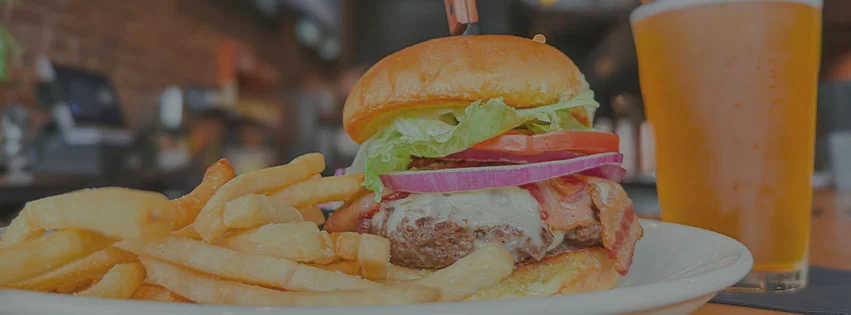 Juicy American cheeseburger with fries and a cold beer