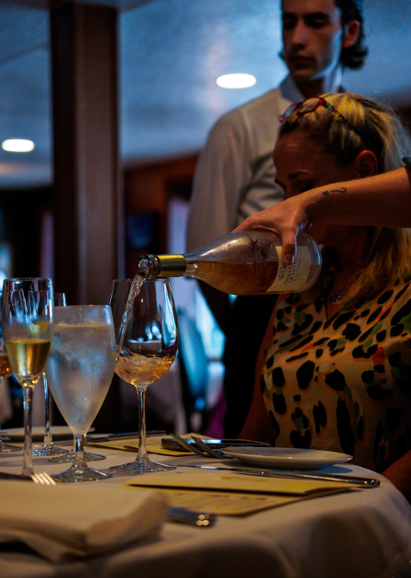 Server pouring wine at an elegant restaurant table