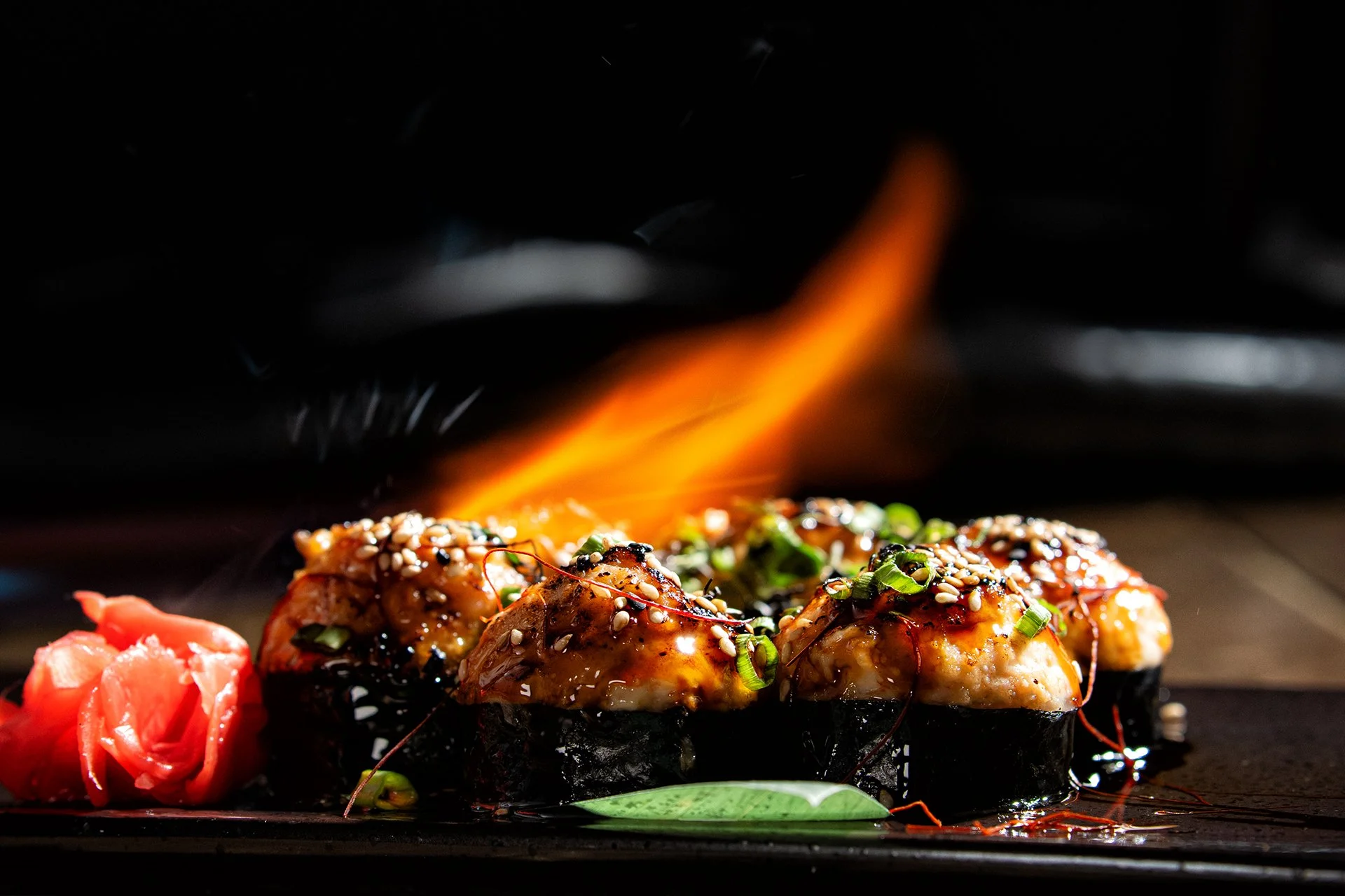 Flame-seared sushi rolls with eel sauce and garnishes