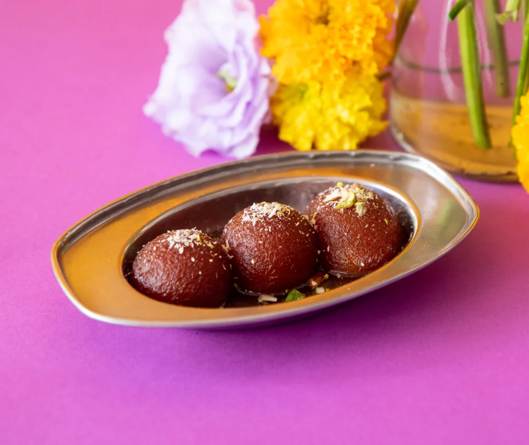 Delicious Indian gulab jamun served in a silver dish