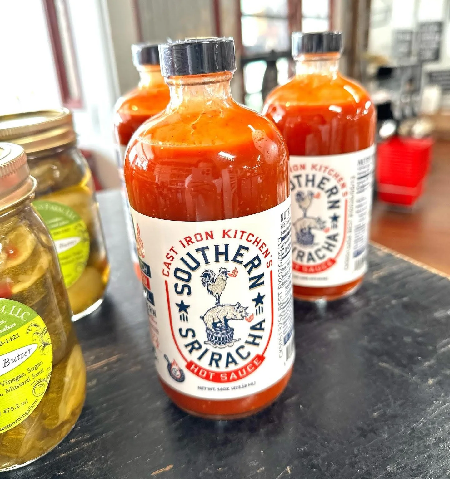 Bottles of Southern Sriracha hot sauce on a rustic table