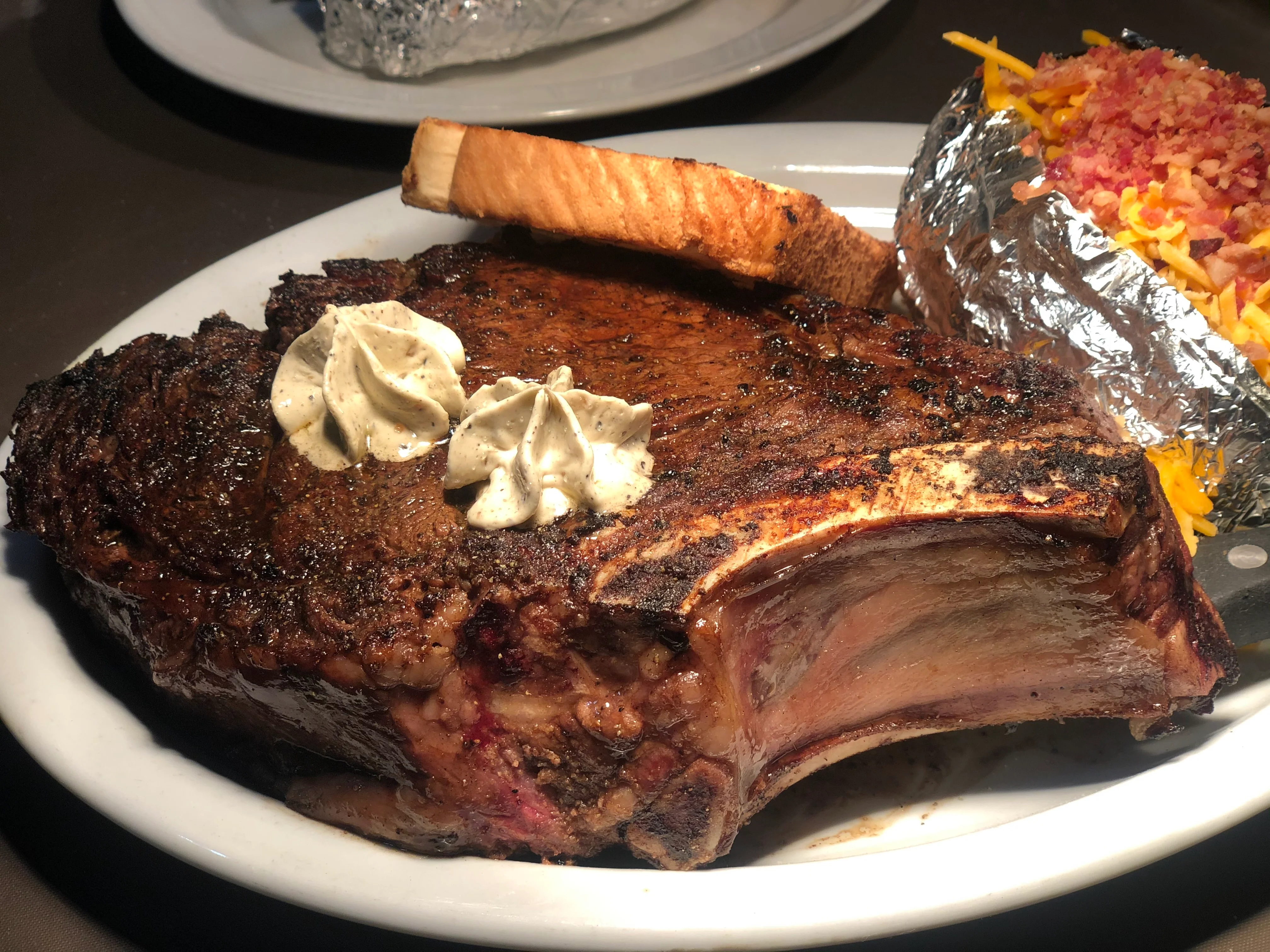 Juicy ribeye steak with garlic butter and baked potato, classic American cuisine