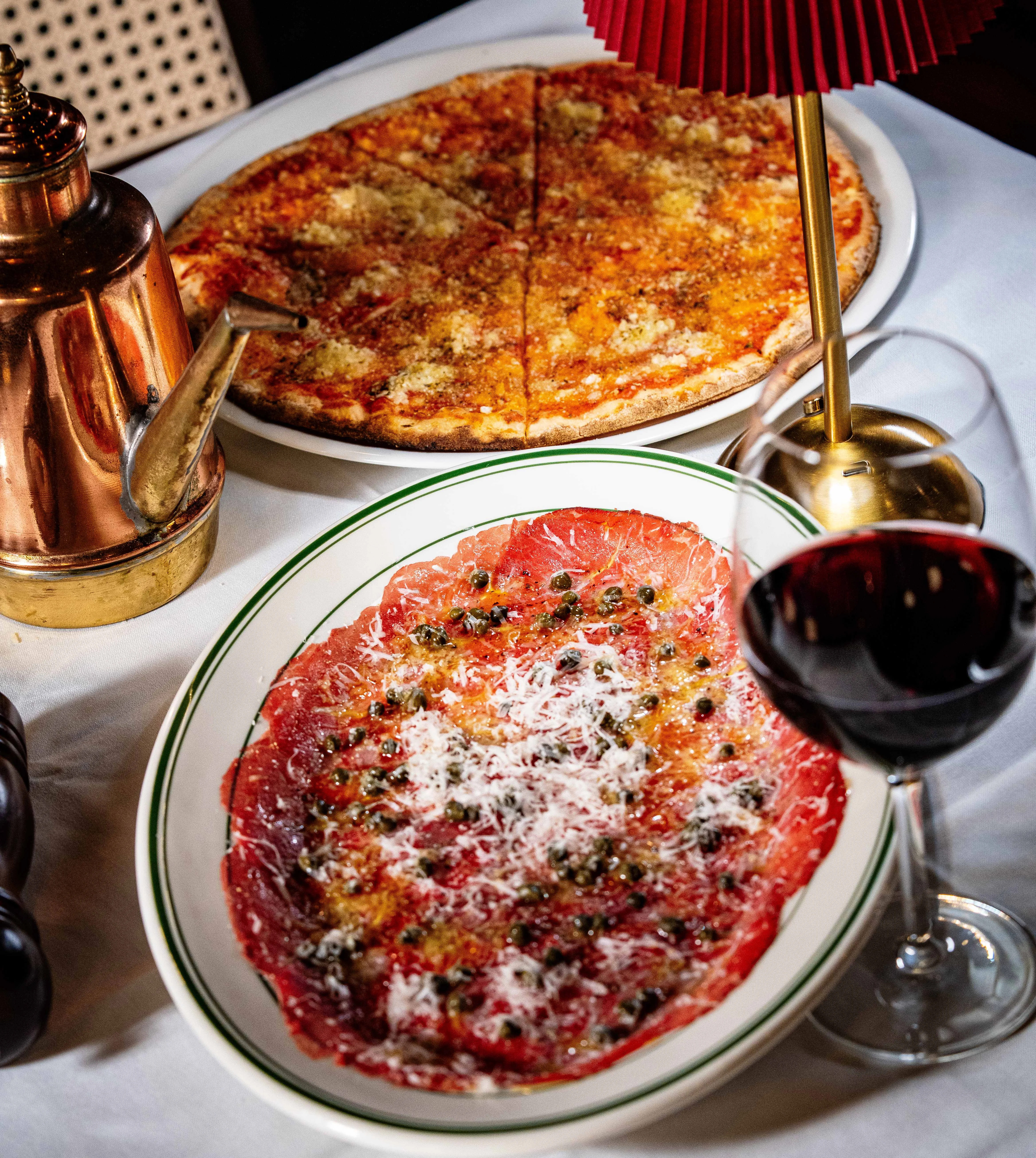 Italian carpaccio with red wine and pizza on a restaurant table