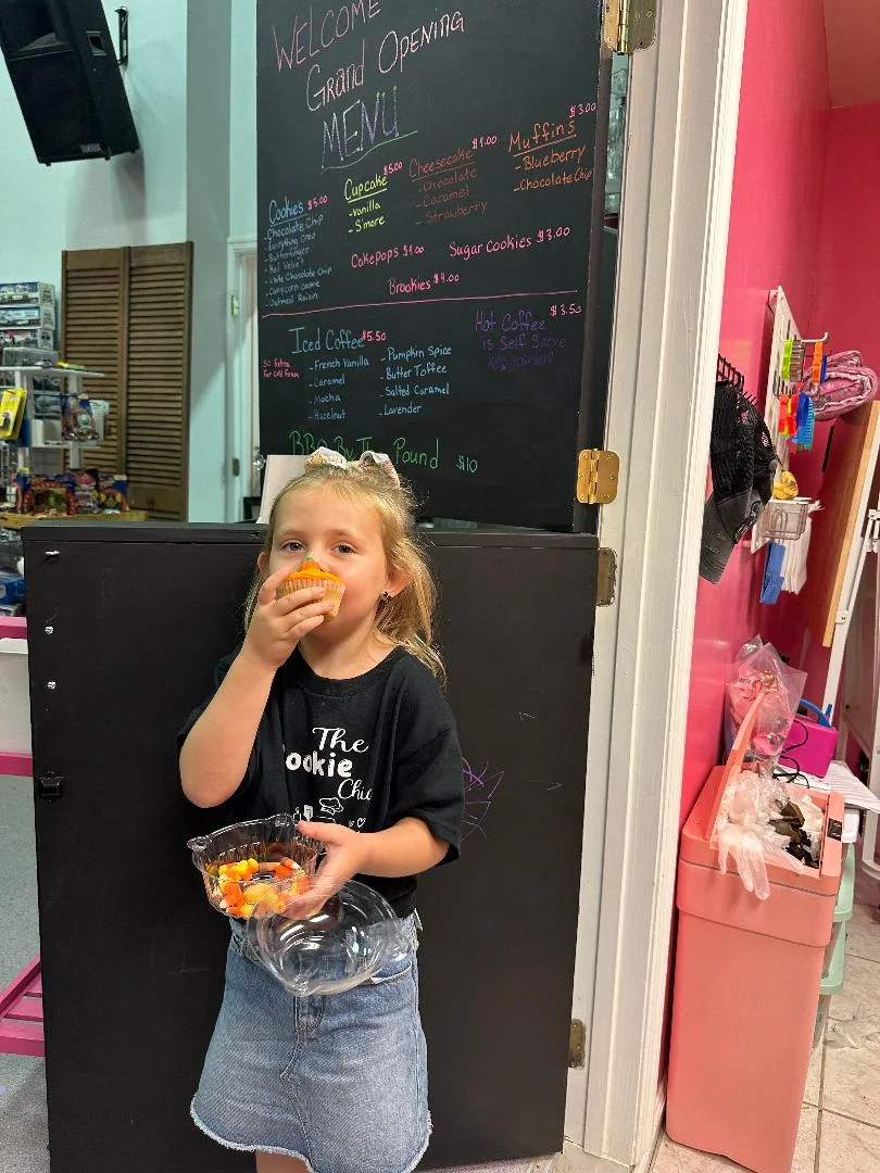 Child enjoying a cupcake at a bakery grand opening