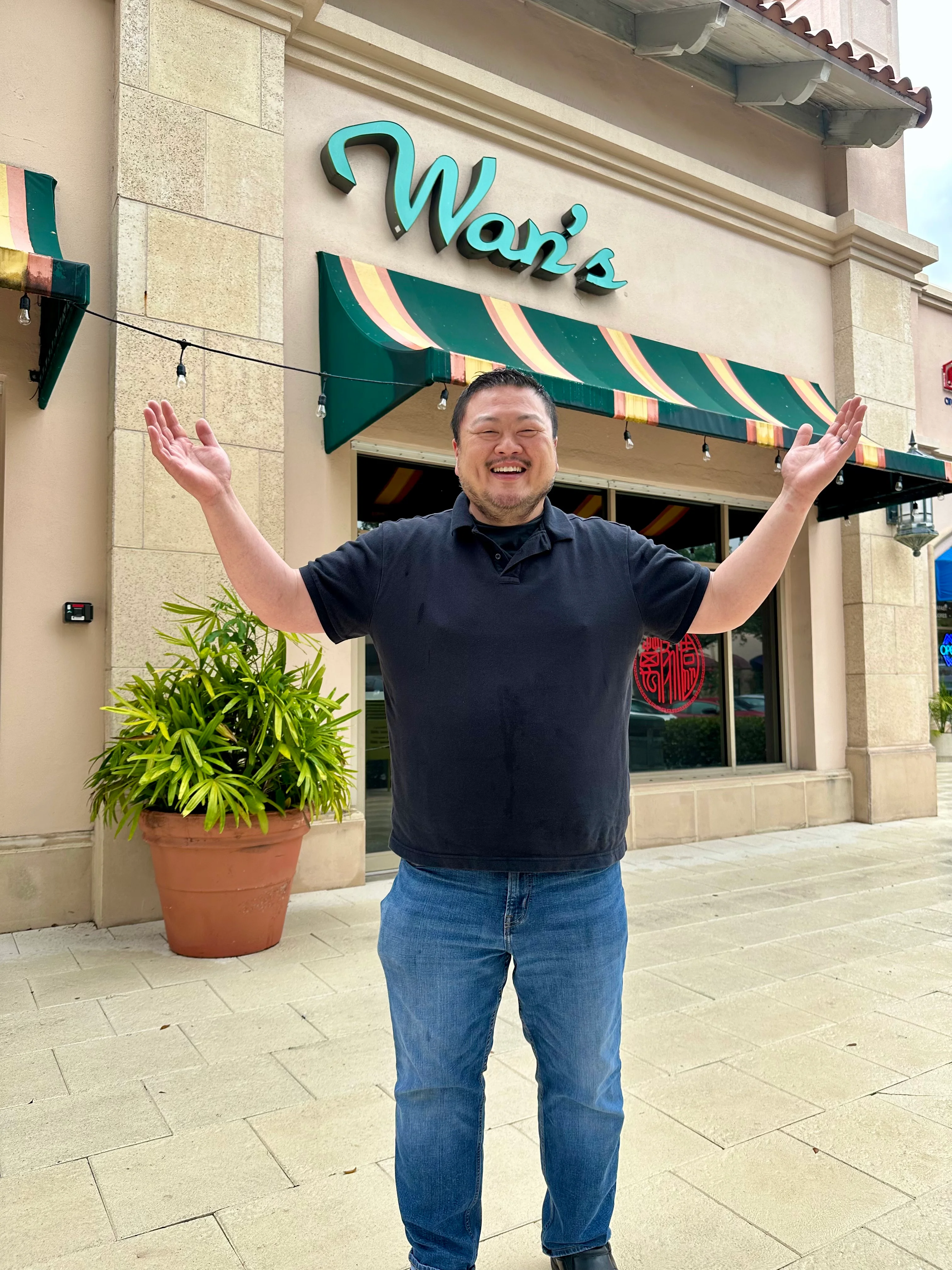Welcoming restaurant owner outside Wan's restaurant