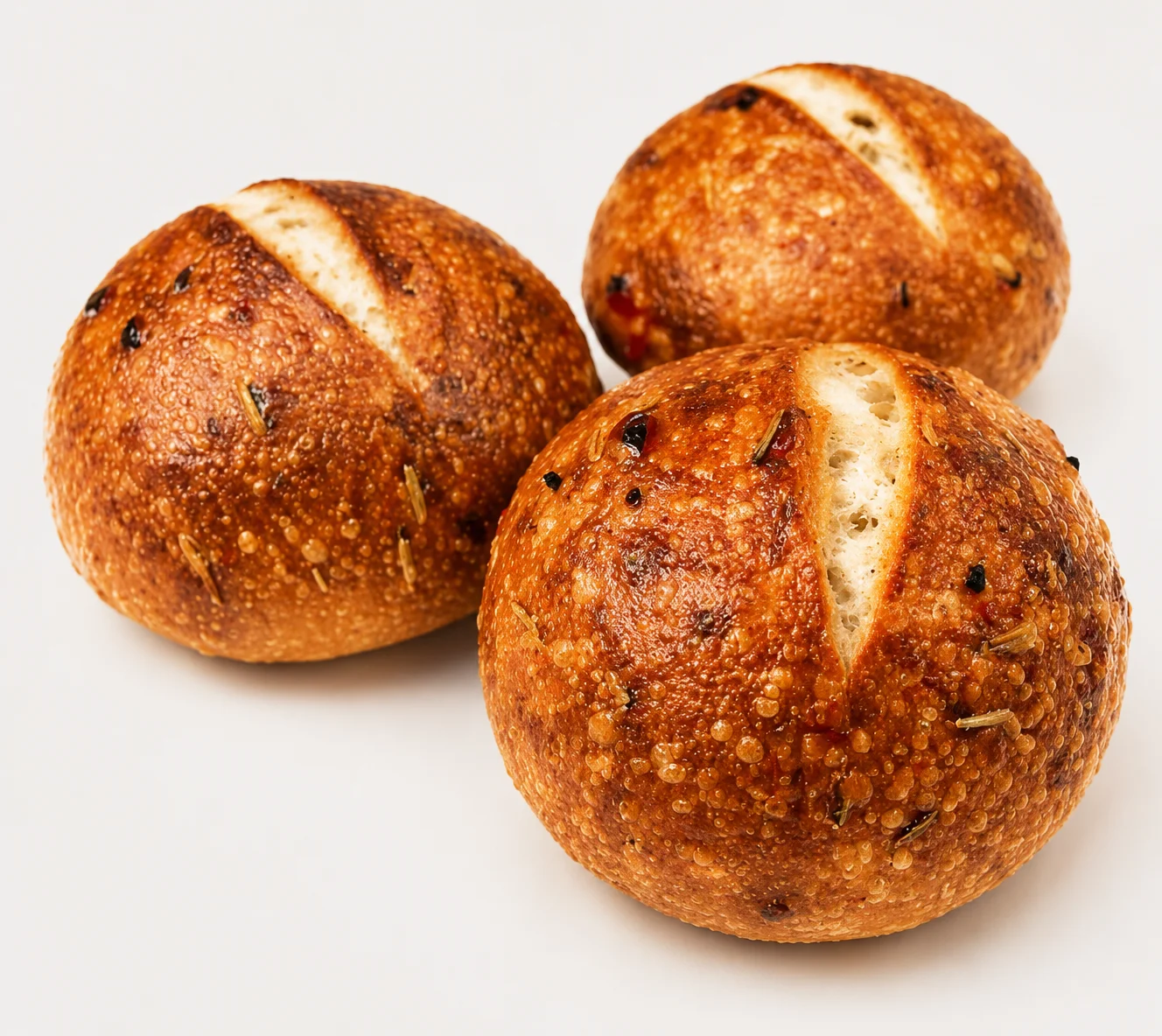 Three freshly baked round bread rolls with a golden crust.
