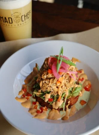 Pulled chicken arepa topped with pickled onions