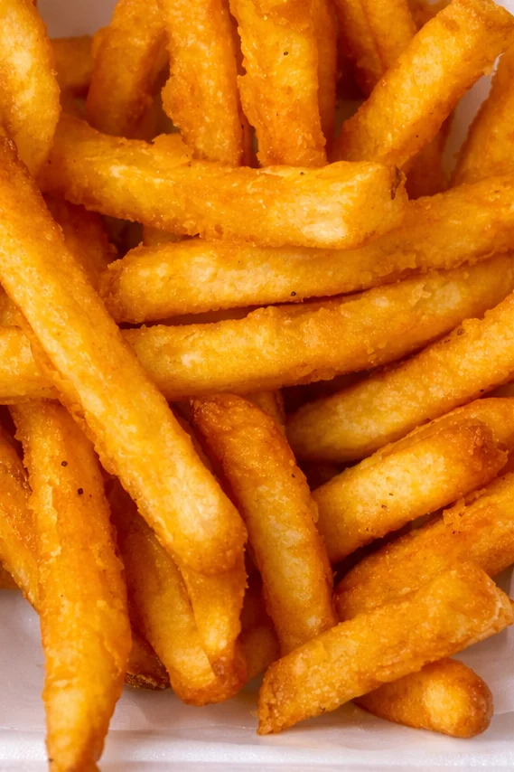 A serving of regular fries in a white container.