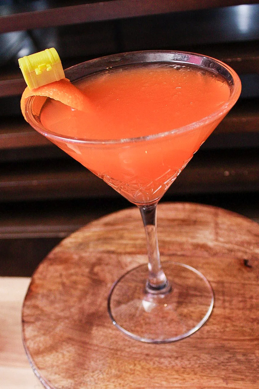 Vibrant cocktail garnished with celery and orange twist