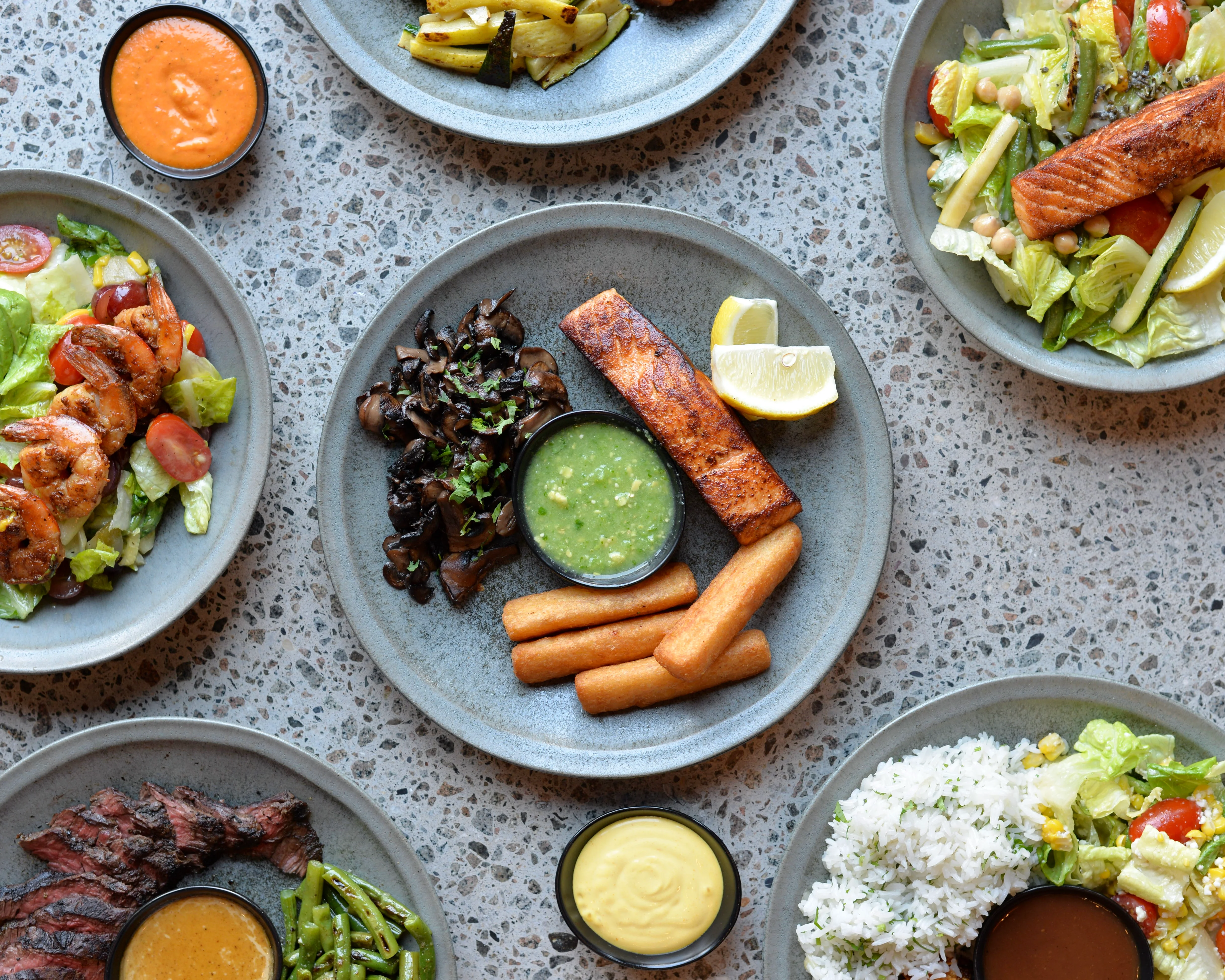 Assorted Latin American dishes with shrimp salad and grilled salmon