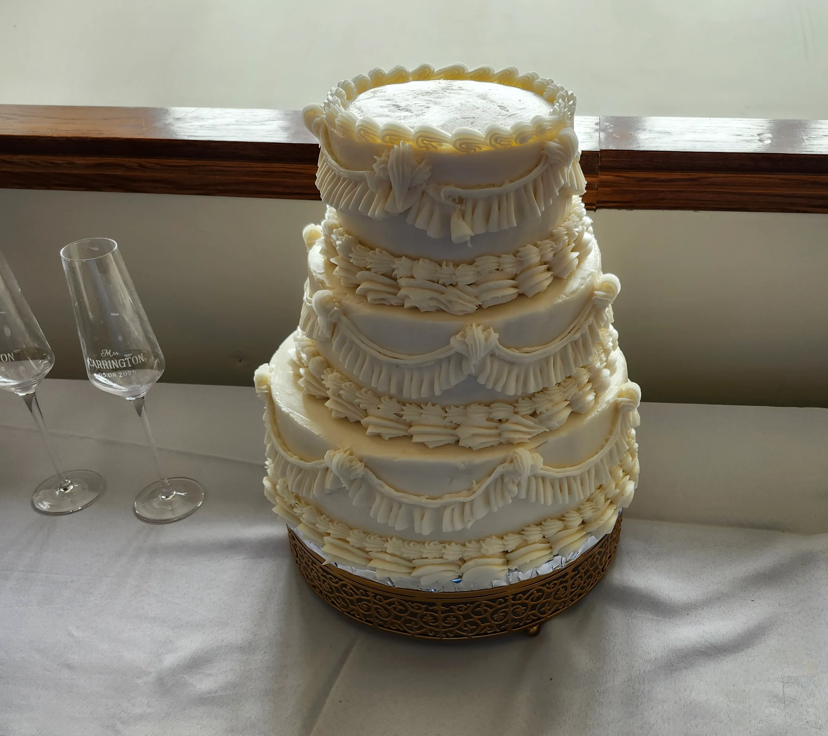 Tiered round cake decorated in a vintage style displayed on a table for a wedding.
