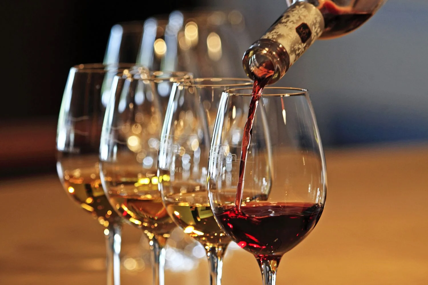 Pouring red wine into a glass at a wine tasting event