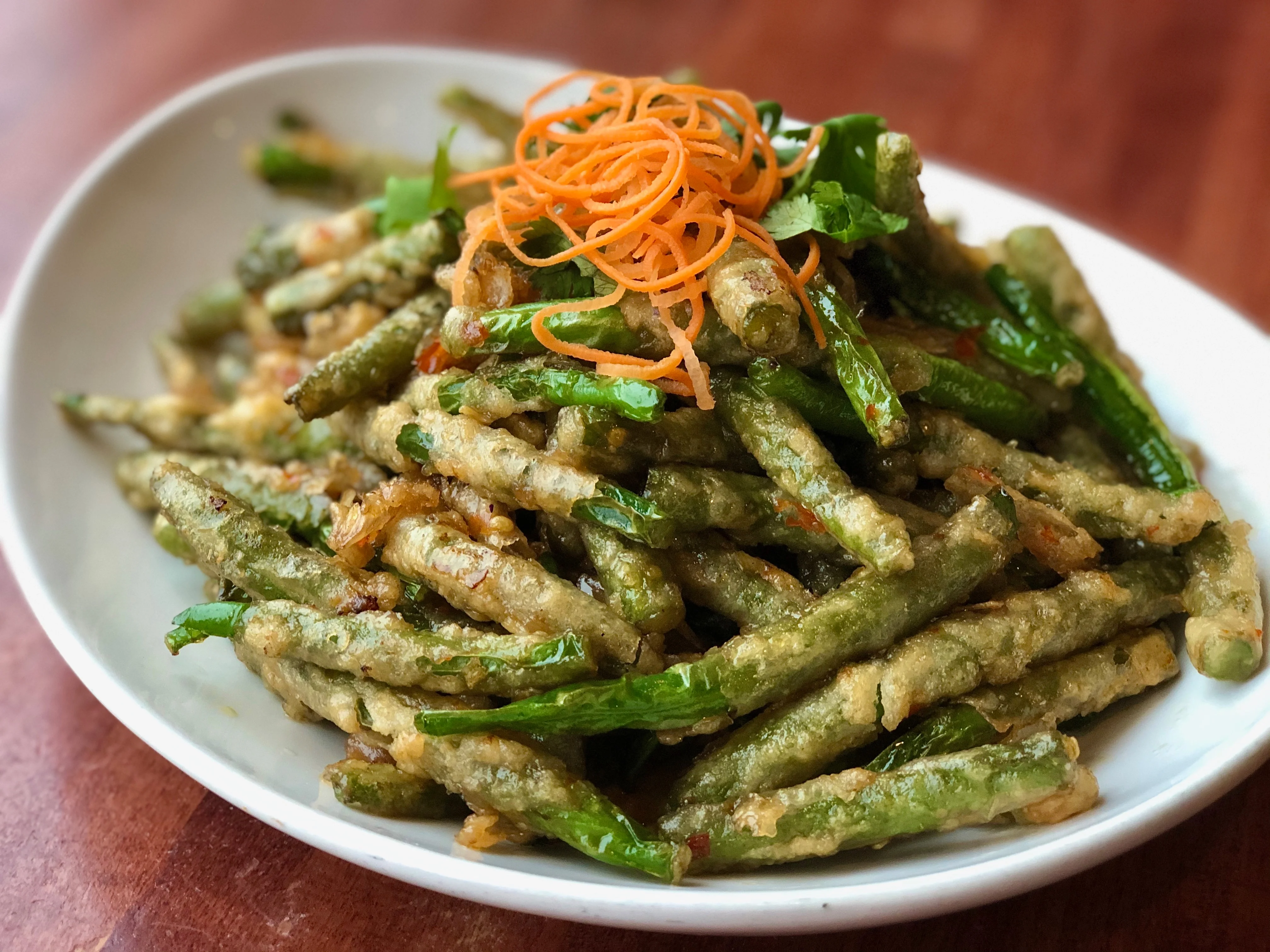 Crispy Vietnamese green bean tempura with carrot garnish