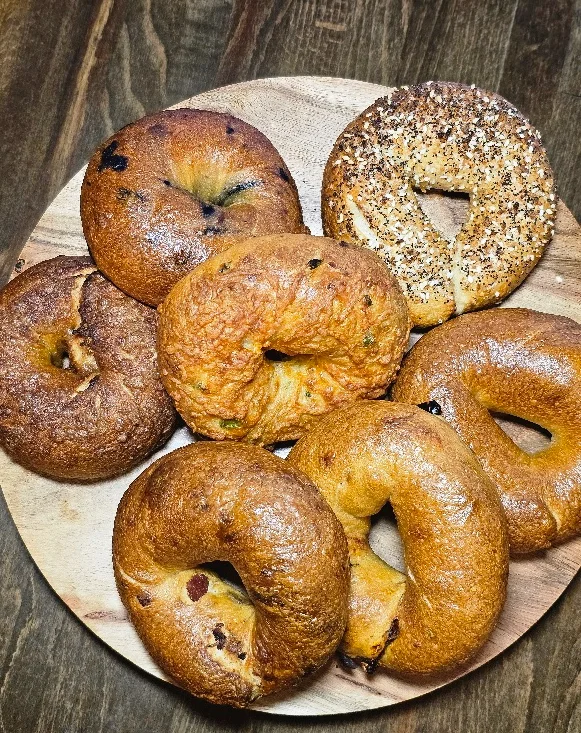 Assorted bagels on a wooden platter